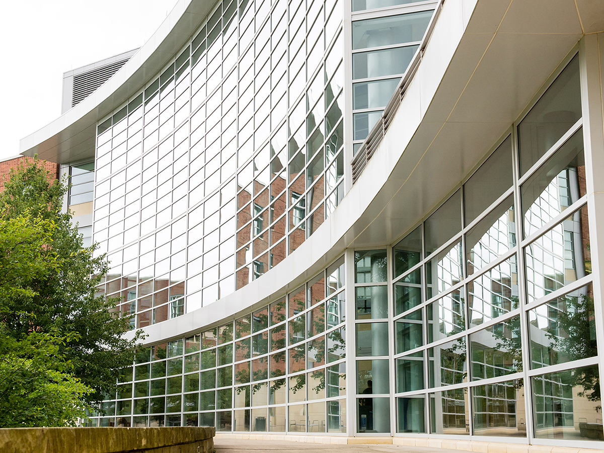 A photo of the curved section of the Business Building that features all rectangular windows outlined by gray window panes.