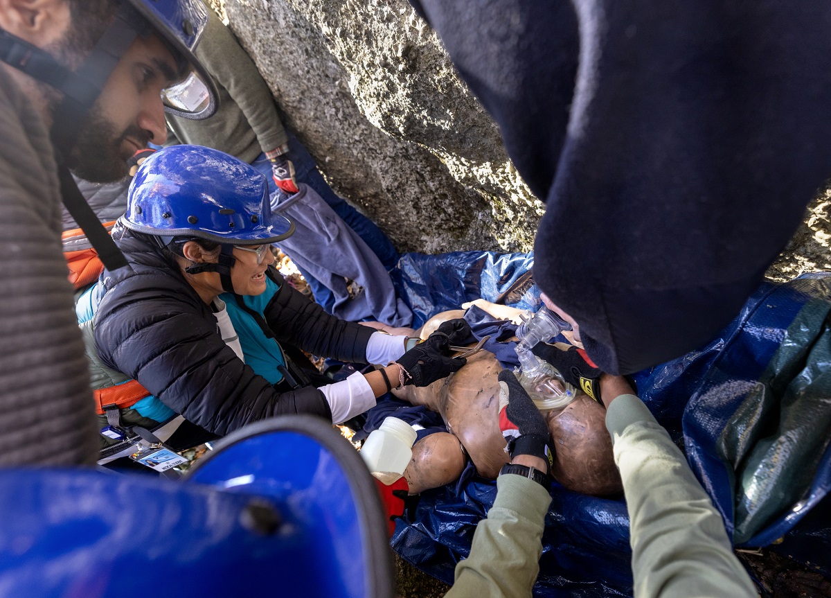 Students participate in a simulated rope rescue training exercise, providing care to an mannequin simulating an injured rock climber