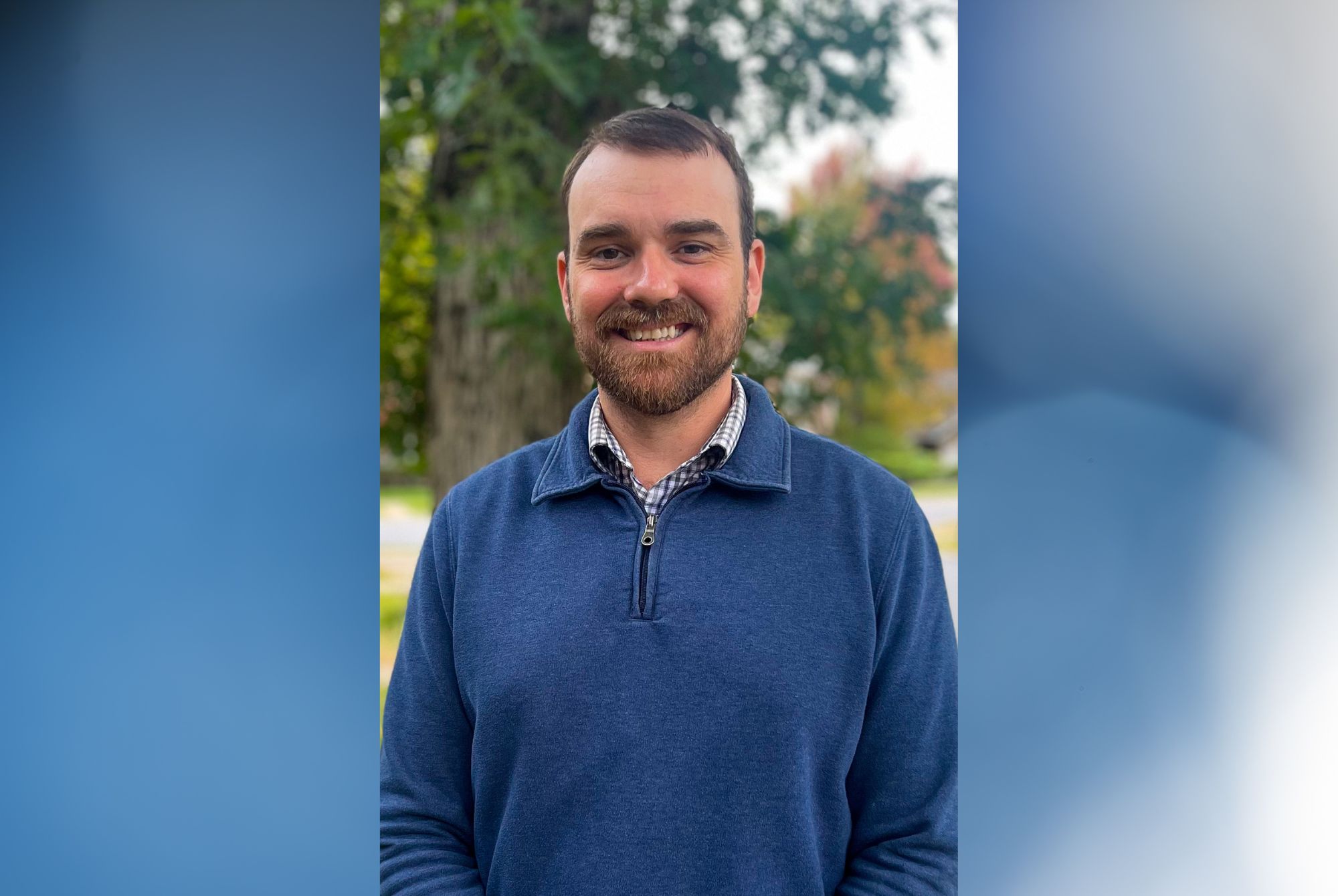 Man in blue sweater smiling