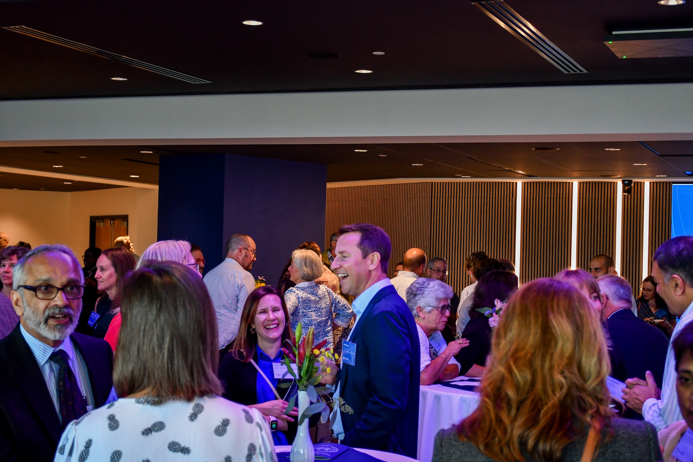 Faculty mingle around cocktail tables