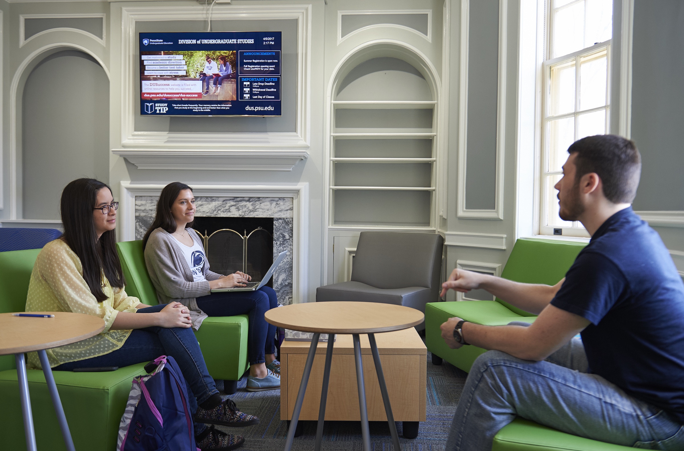 Three students talking in Grange Building lobby