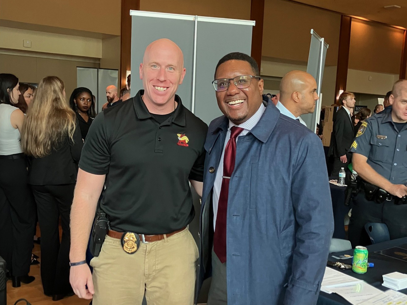 Altoona Police Cpl Stickel #306 (left) with Dean Clarence Lang (right) behind a table in Alumni Hall, HUB-Robeson Center at Penn State University Park.