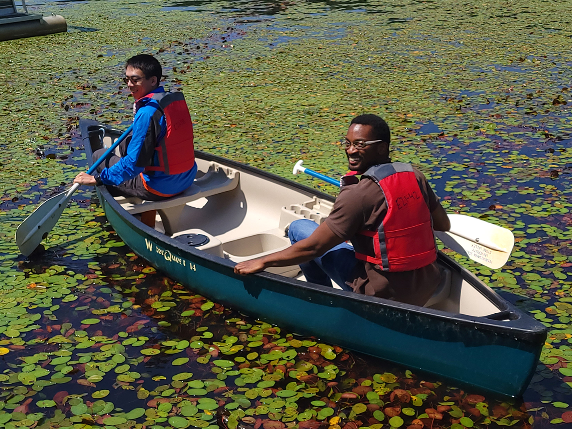 Alex Vera boats on a lake with a fellow graduate student