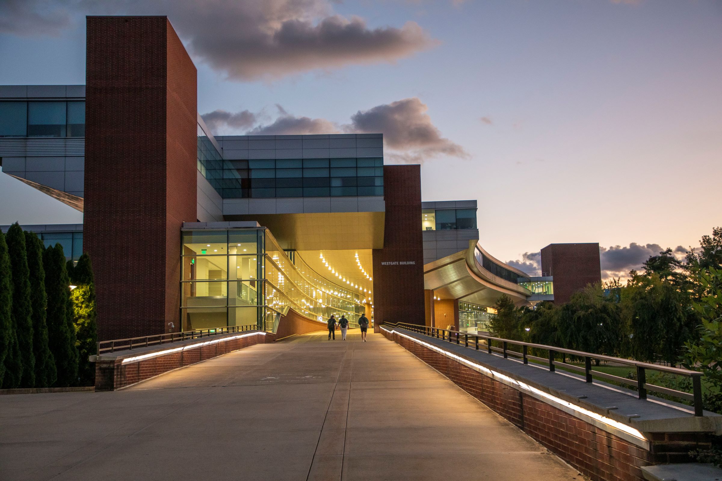 brick and glass campus building at dusk