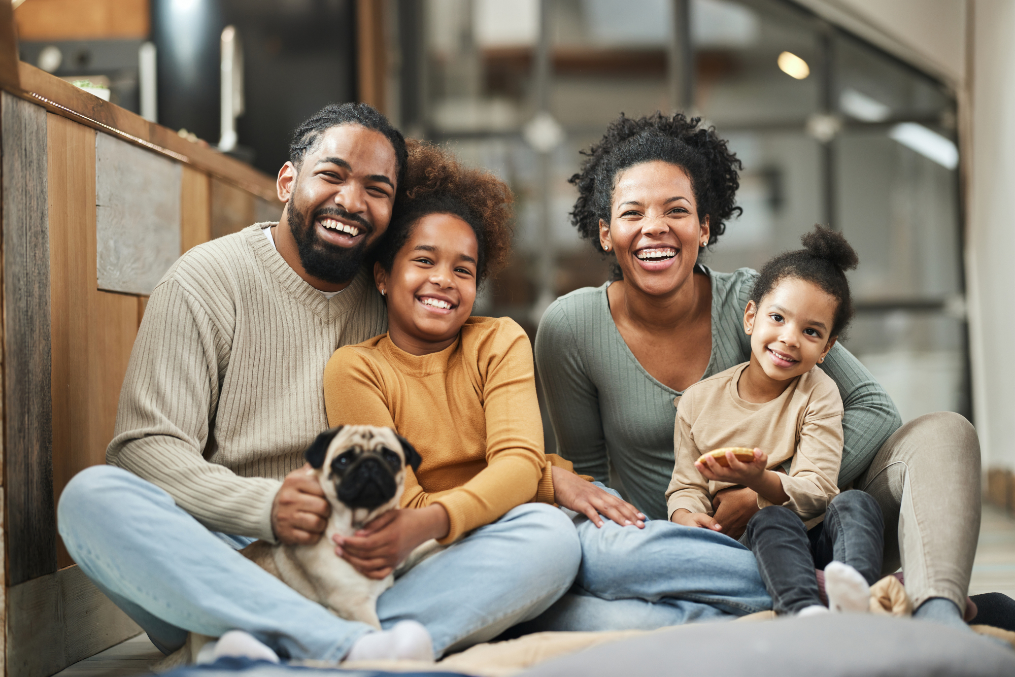 Happy parents with their children and a dog spending time at home.