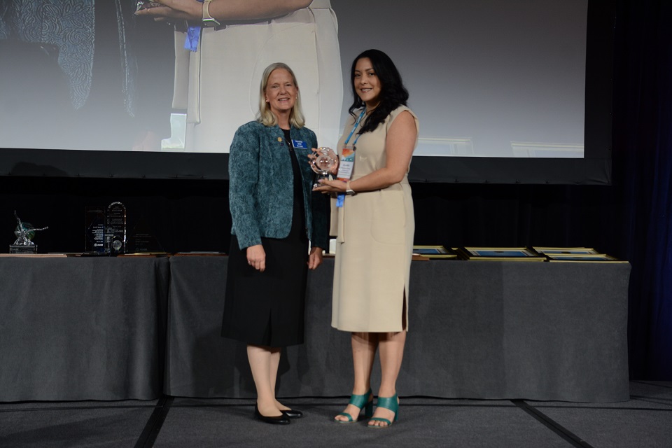 Juliana Vasco-Correa, right, receives an award