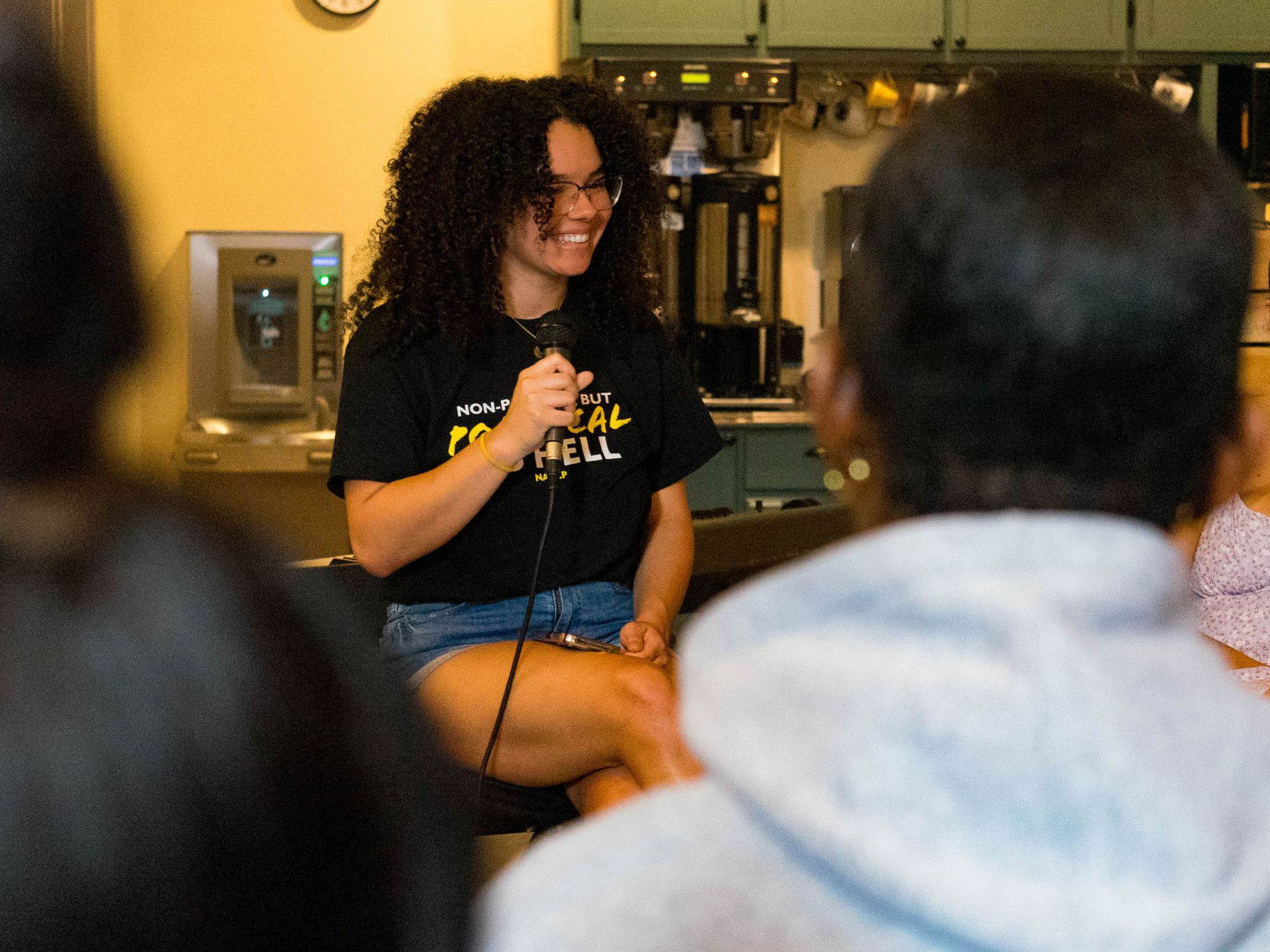 Lenneya Murray smiles while holding a microphone.