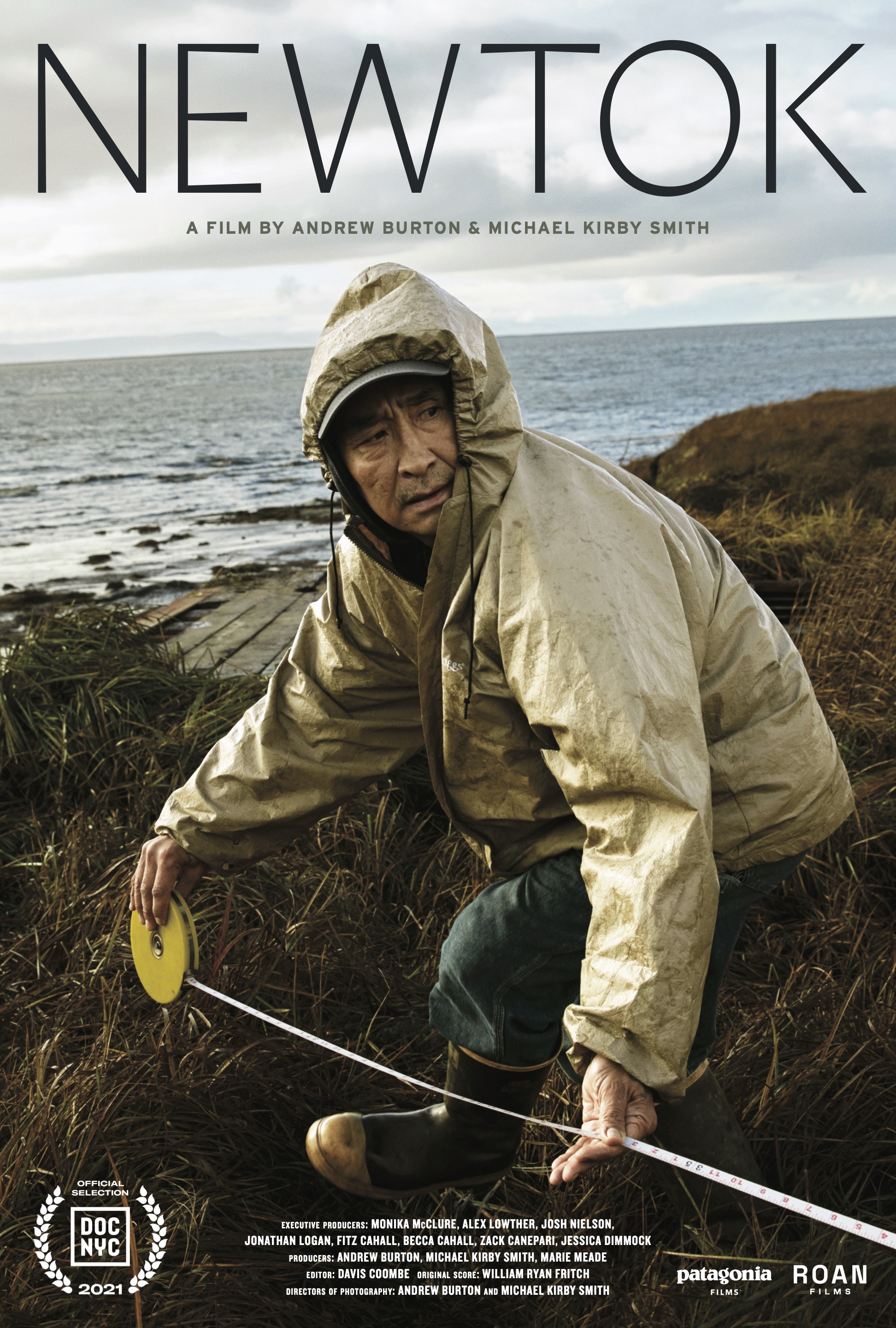 A man in a rain jacket is pictured kneeling near a coastline for the "Newtok" documentary film poster.