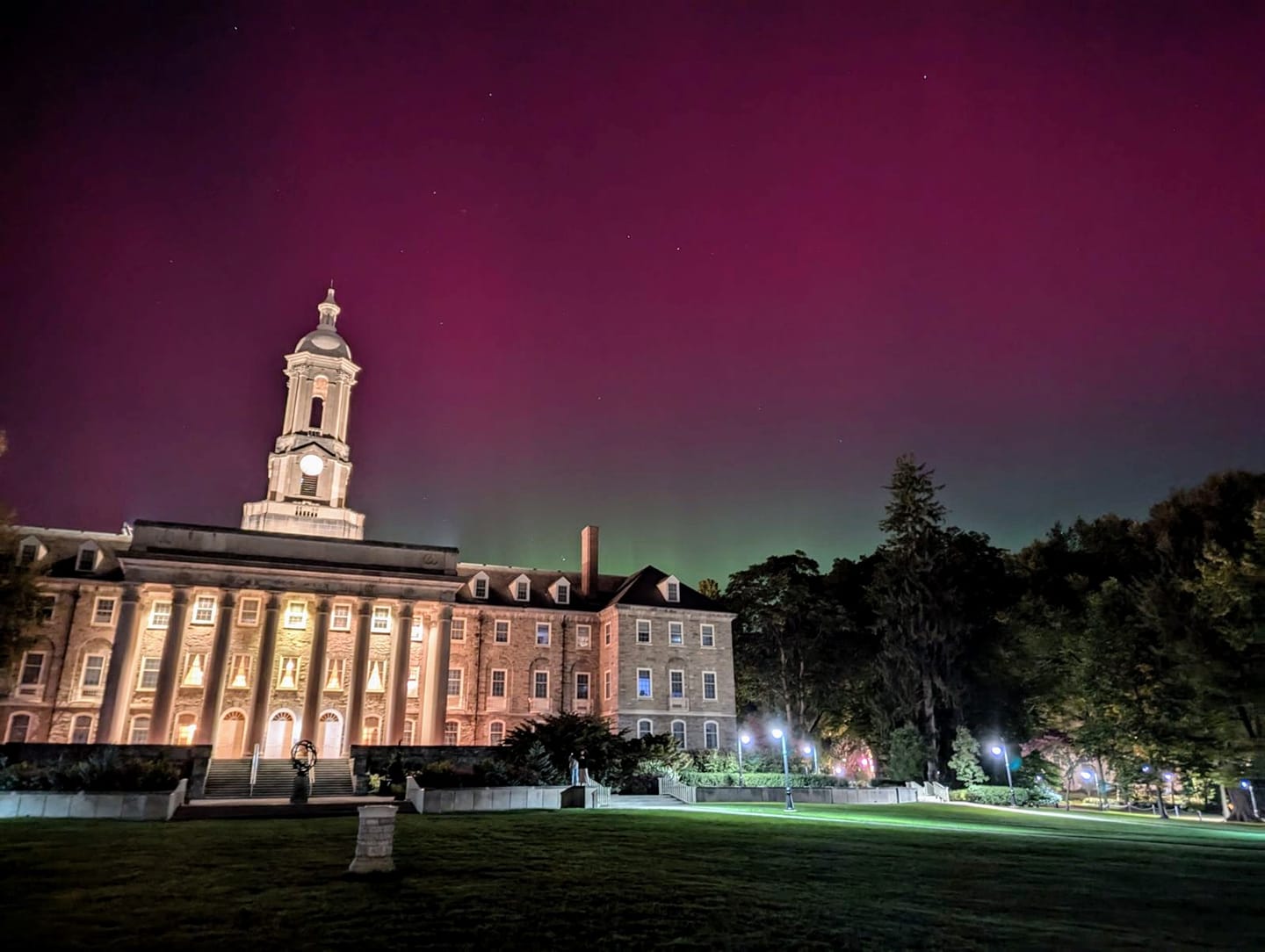 Old Main lit up at night with a purple sky behind it