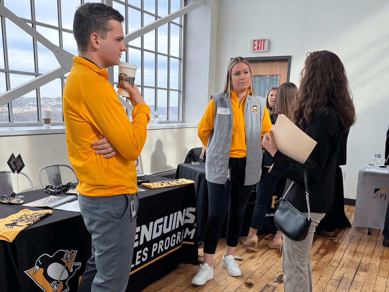 a man and two women standing at table at career fair