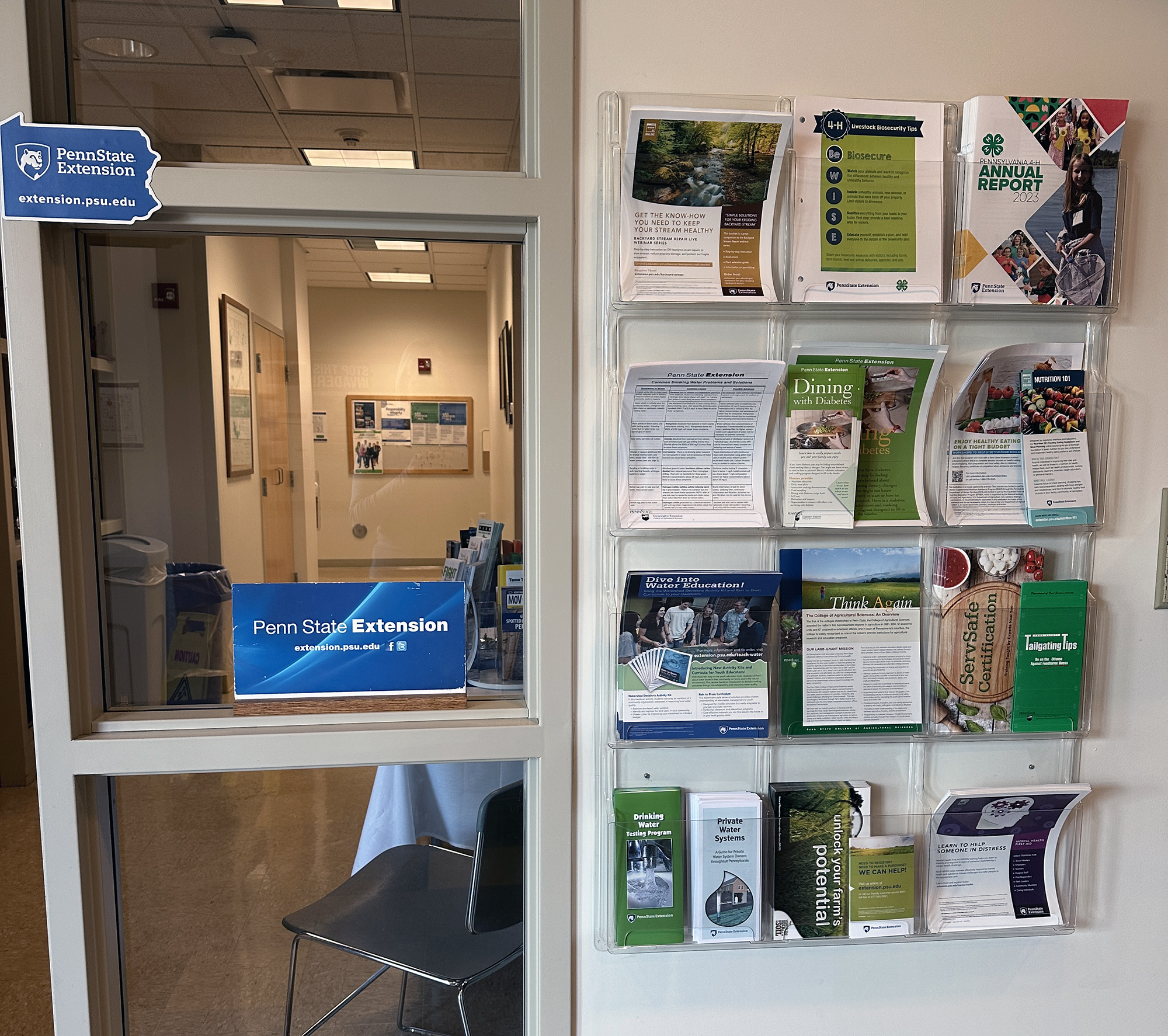 A photo of the Extension offices including a wall holder with various pamphlets and a sign that says Penn State Extension.