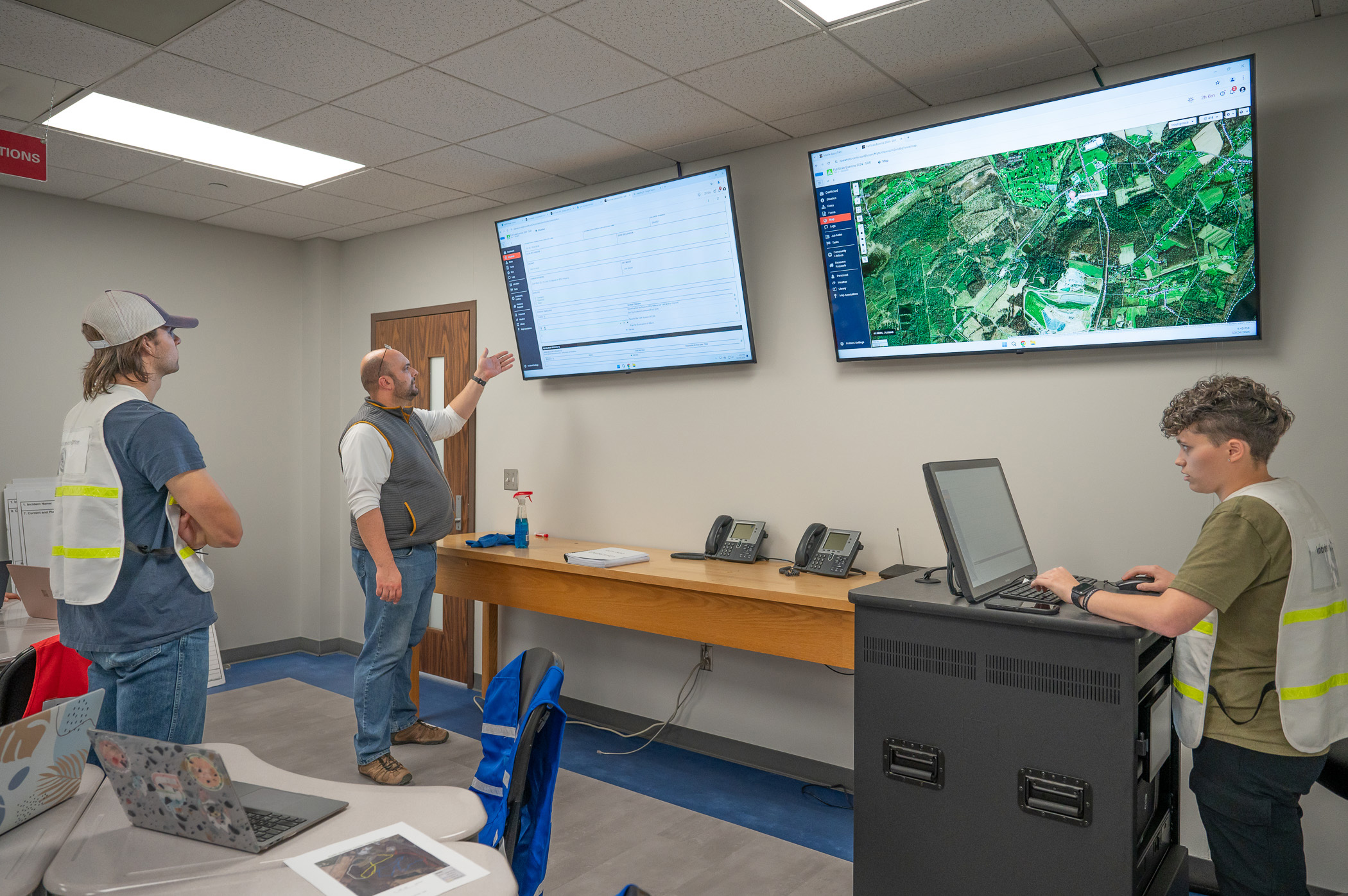 Student in a classroom use software displayed on a large screen.