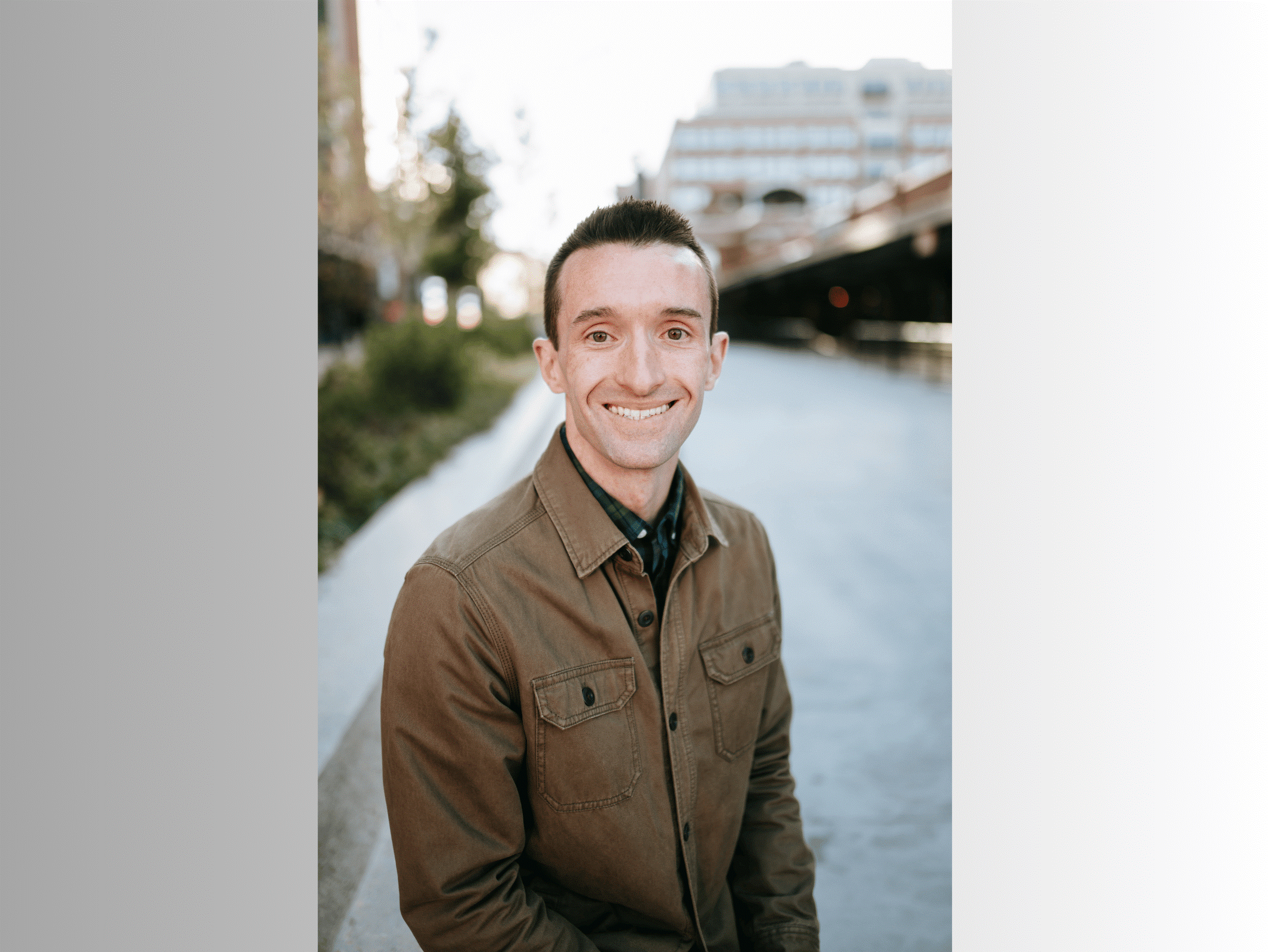 smiling person with short hair and brown jacket