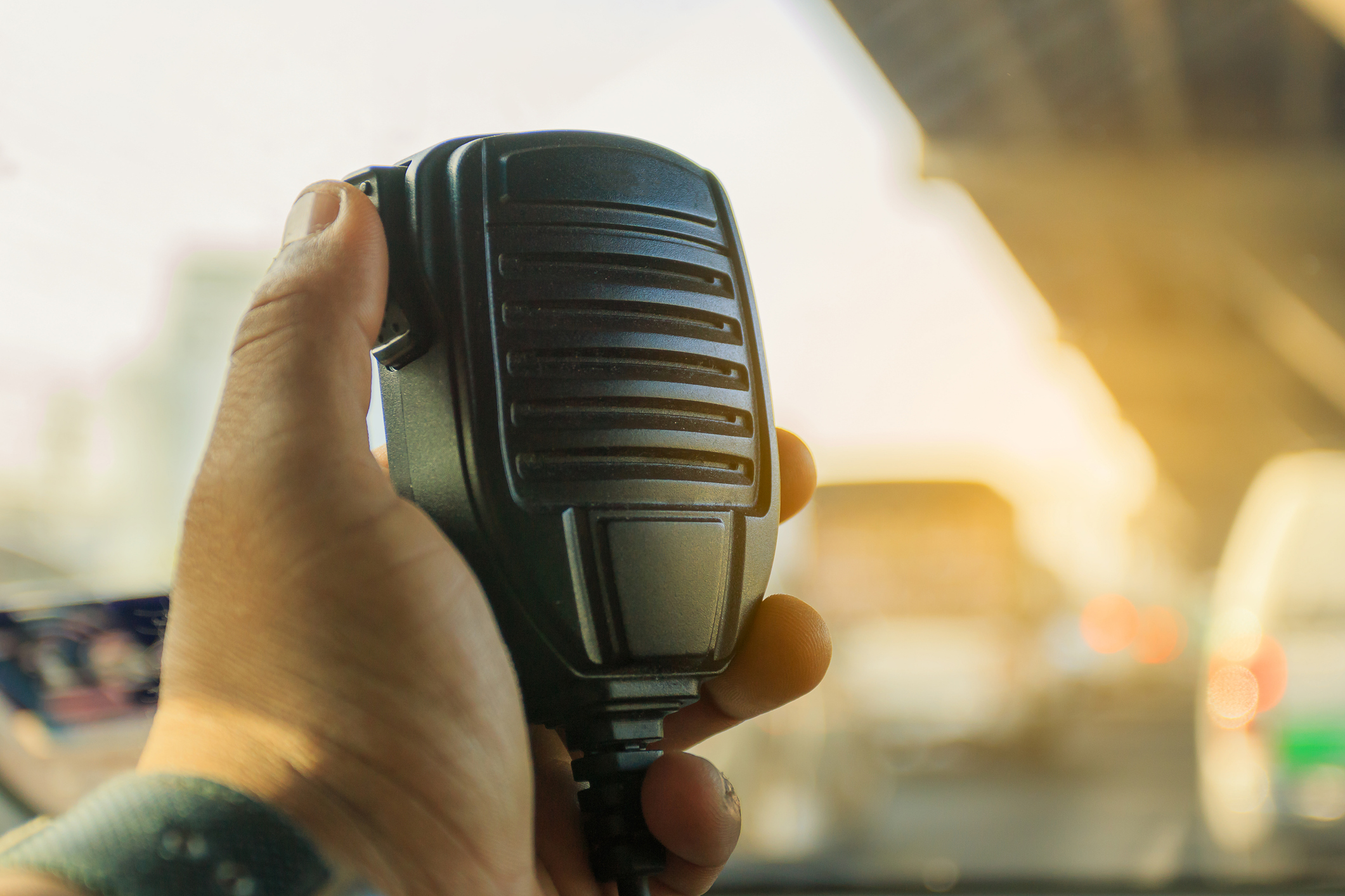 A hand holding a radio handset