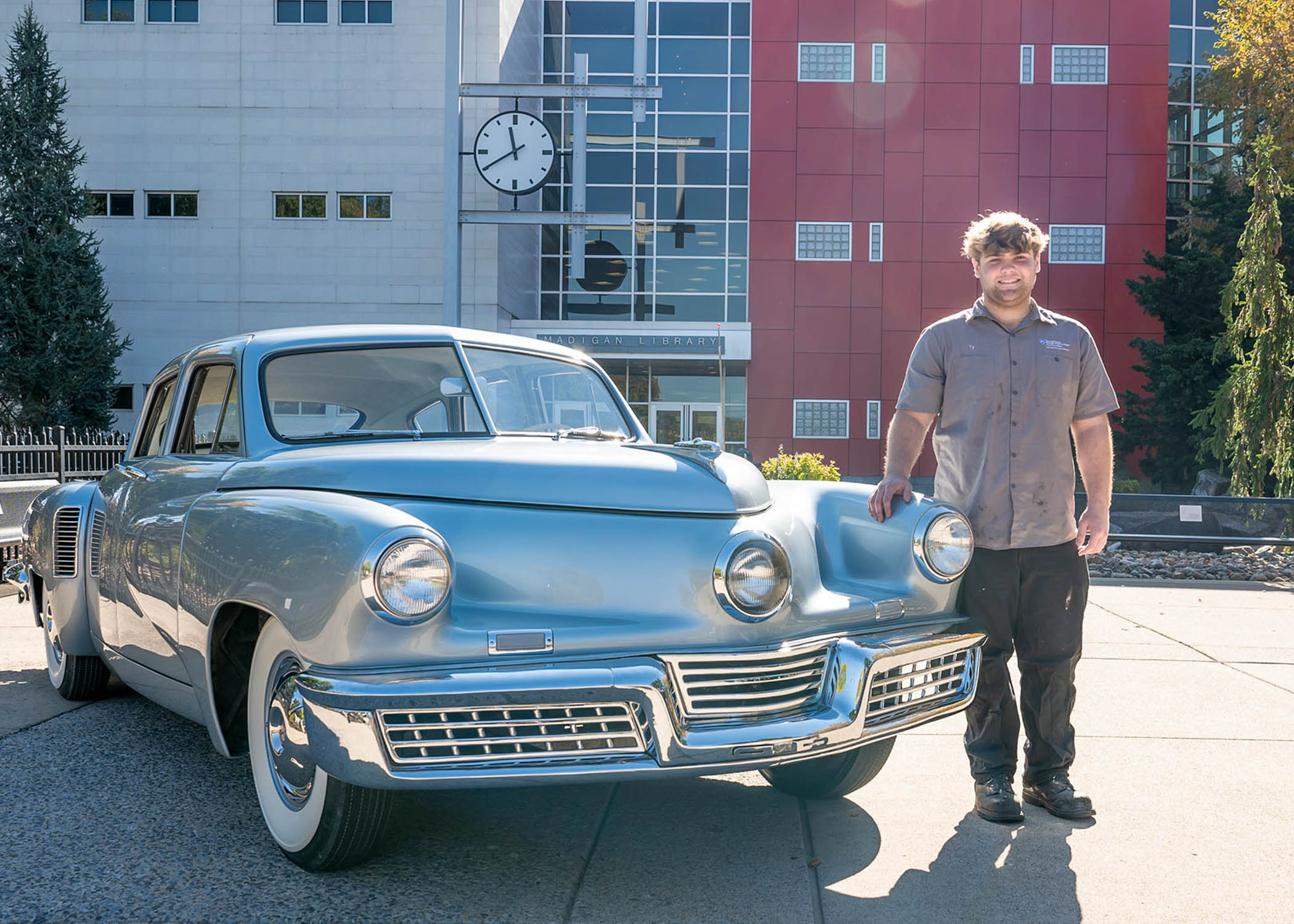 Ty Tucker stands with a restored vintage car