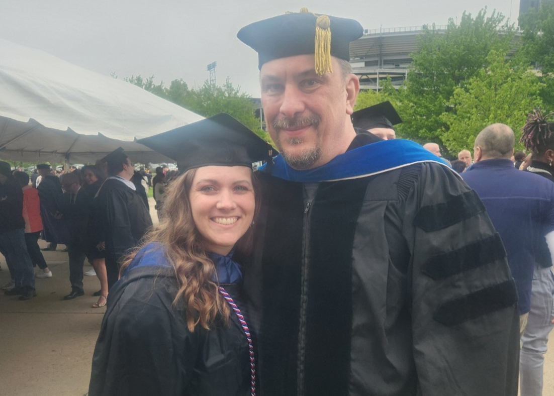 A woman and a man in graduation robes. 