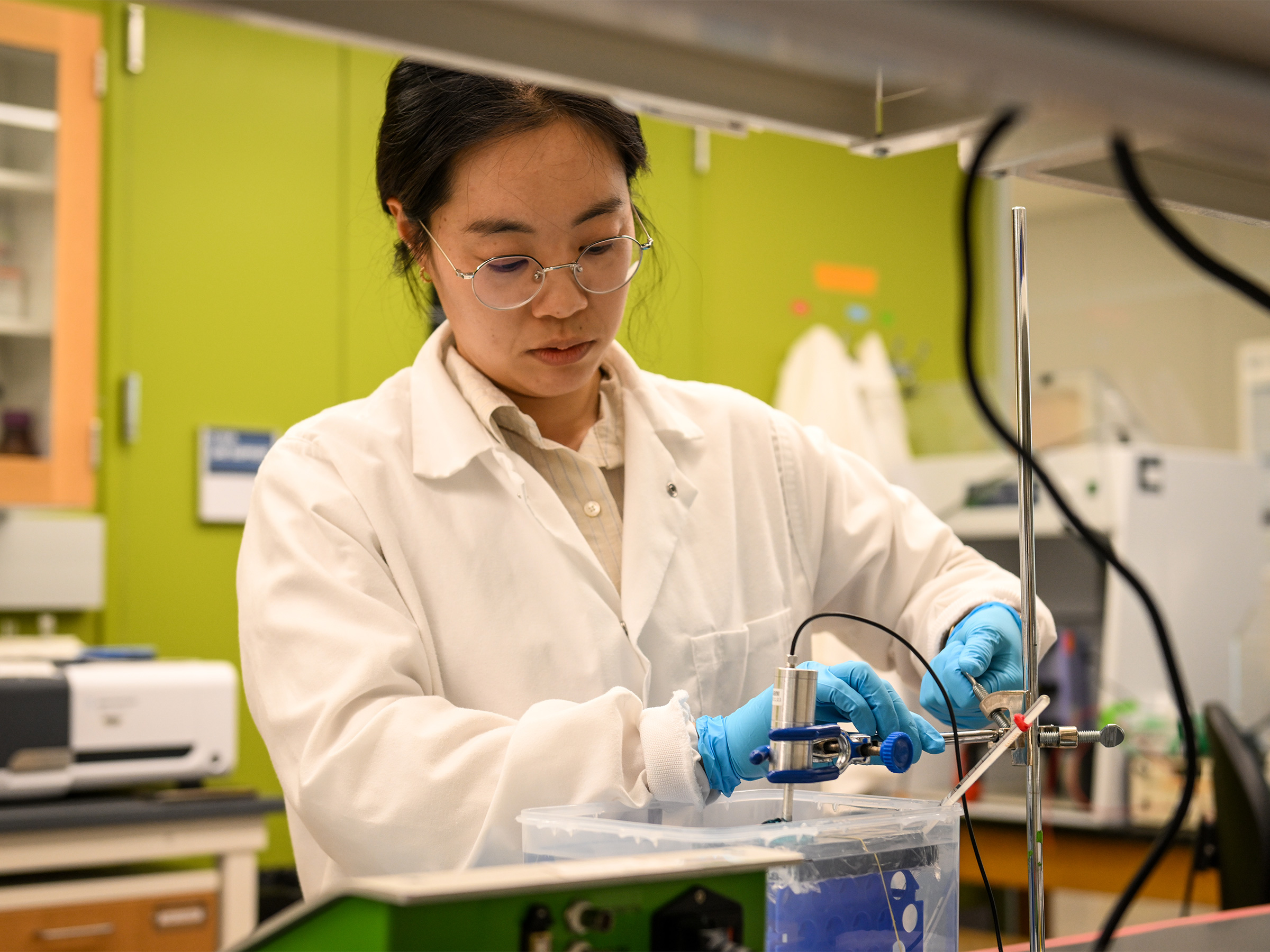 individual wearing white lab coat working in a lab 