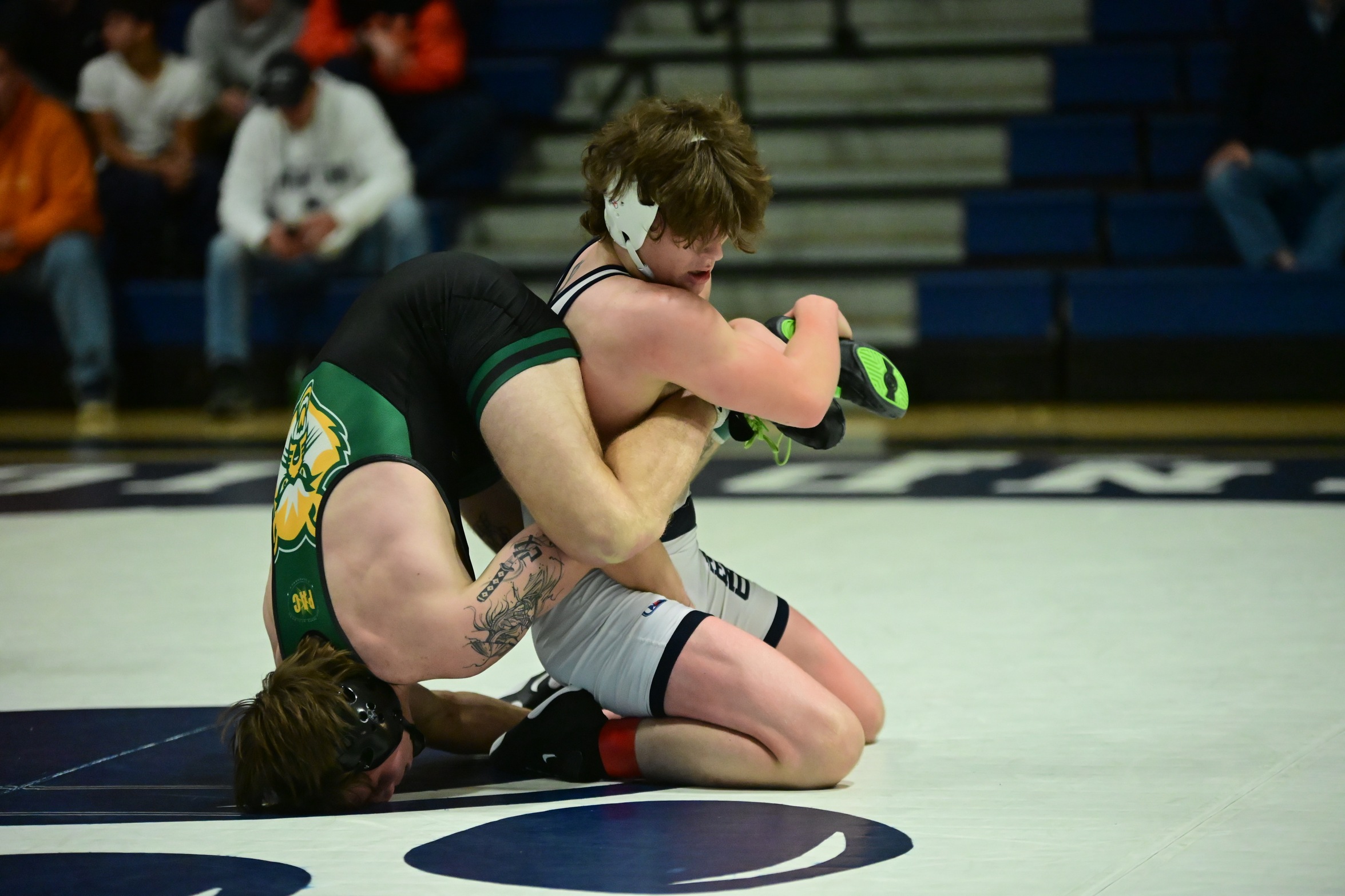 A Penn State Behrend wrestler gains leverage on an opponent, who is upended.