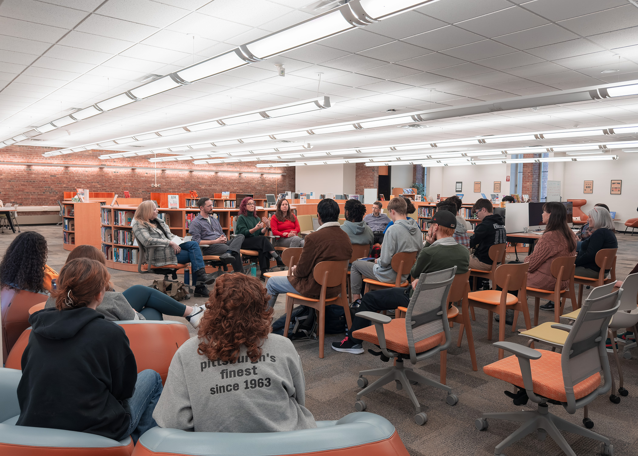 Students and guests listen to faculty speaking panel in library