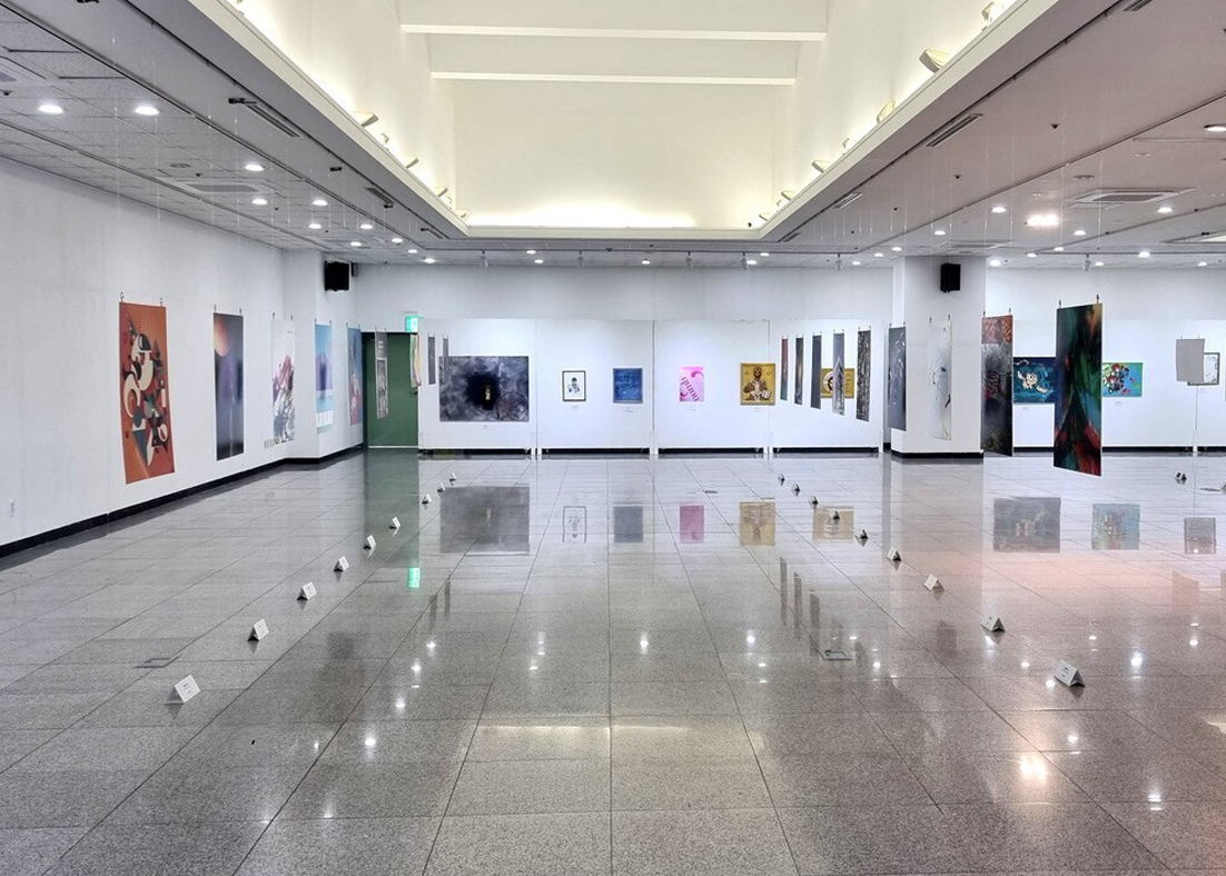 A white art gallery with colorful posters on the walls.