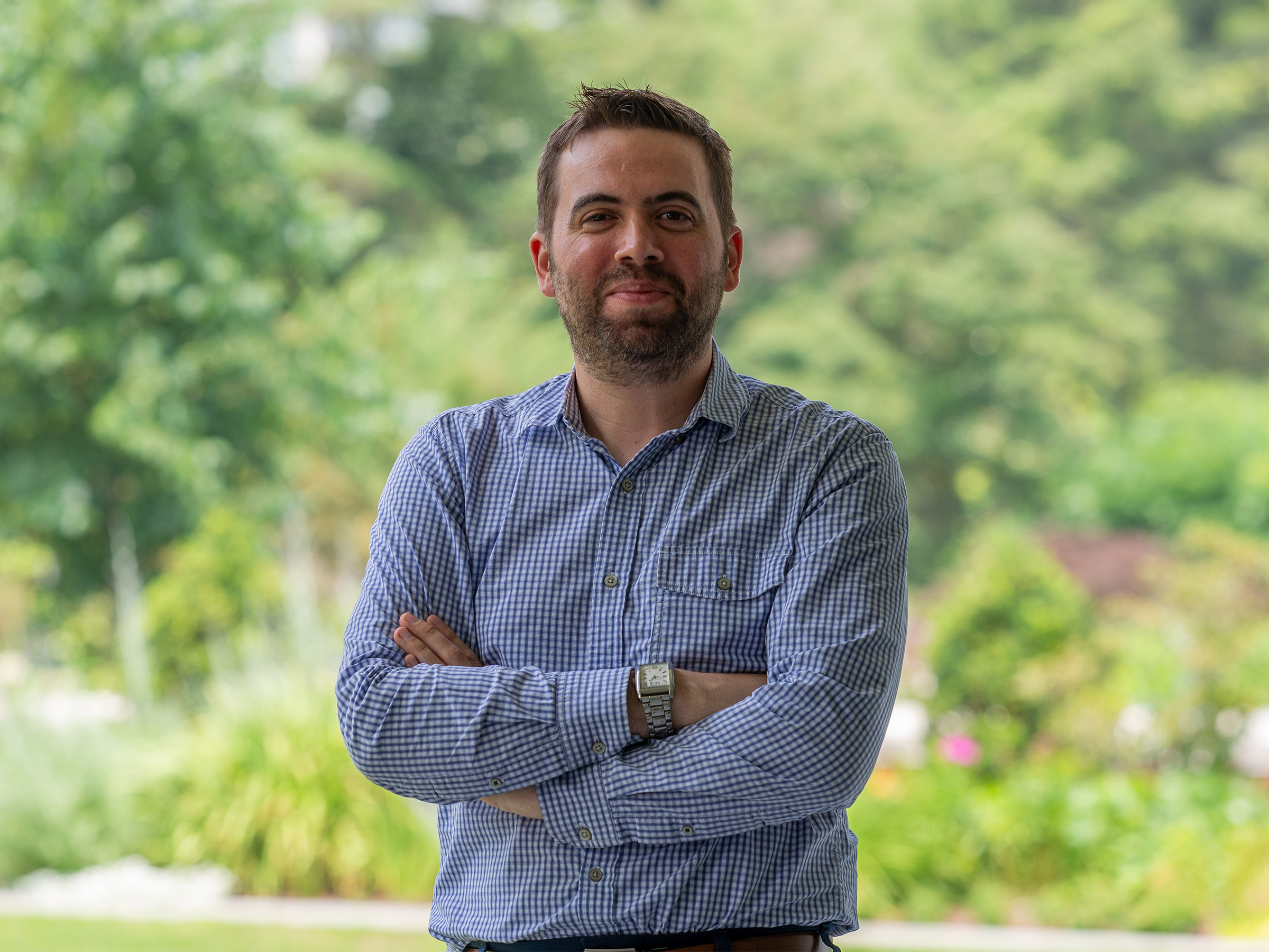 An outdoor portrait of a person in a blue shirt.