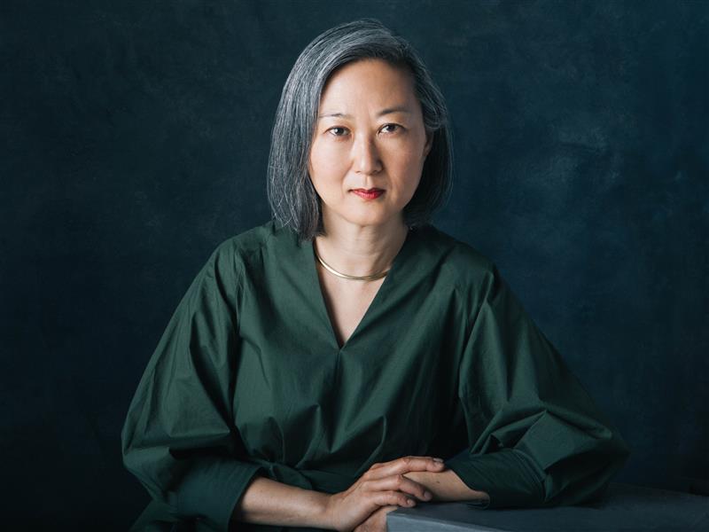 Julie Park headshot, wearing green blouse and black background