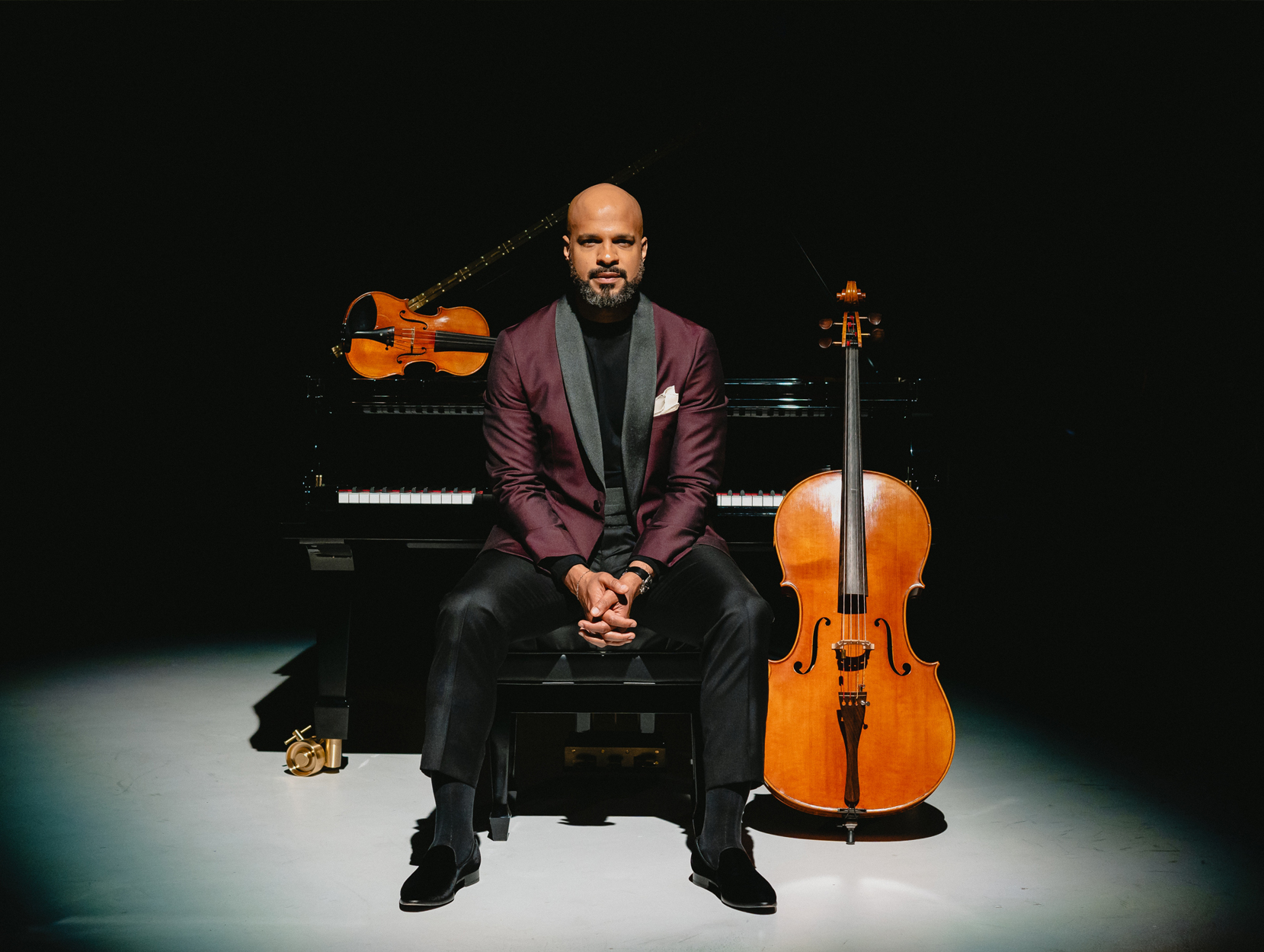 Barron Ryan, sitting at a piano, with a cello and violin