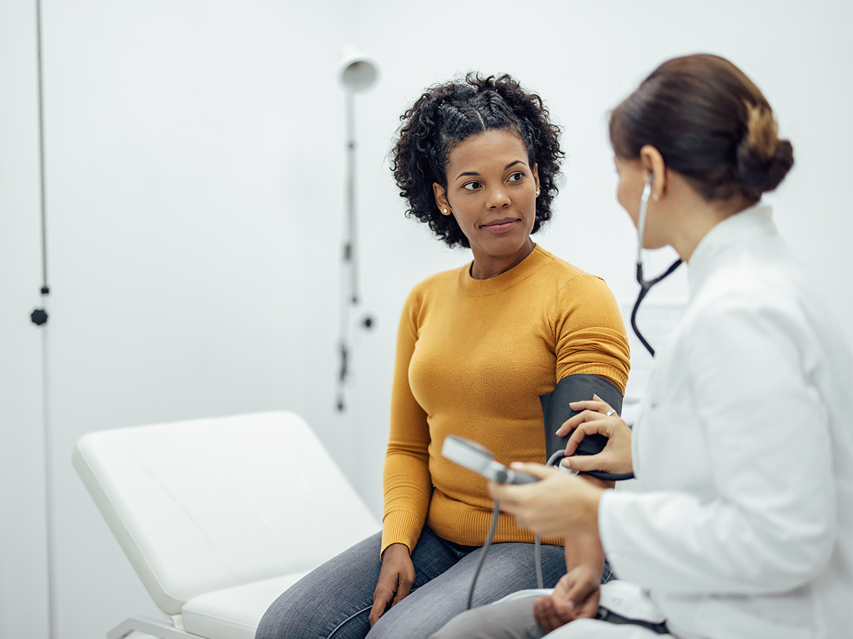 doctor talking to a person sitting in examine room