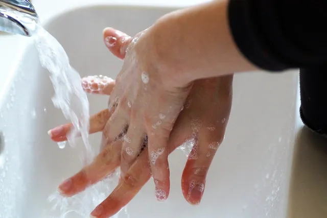 A person washing their hands at a sink