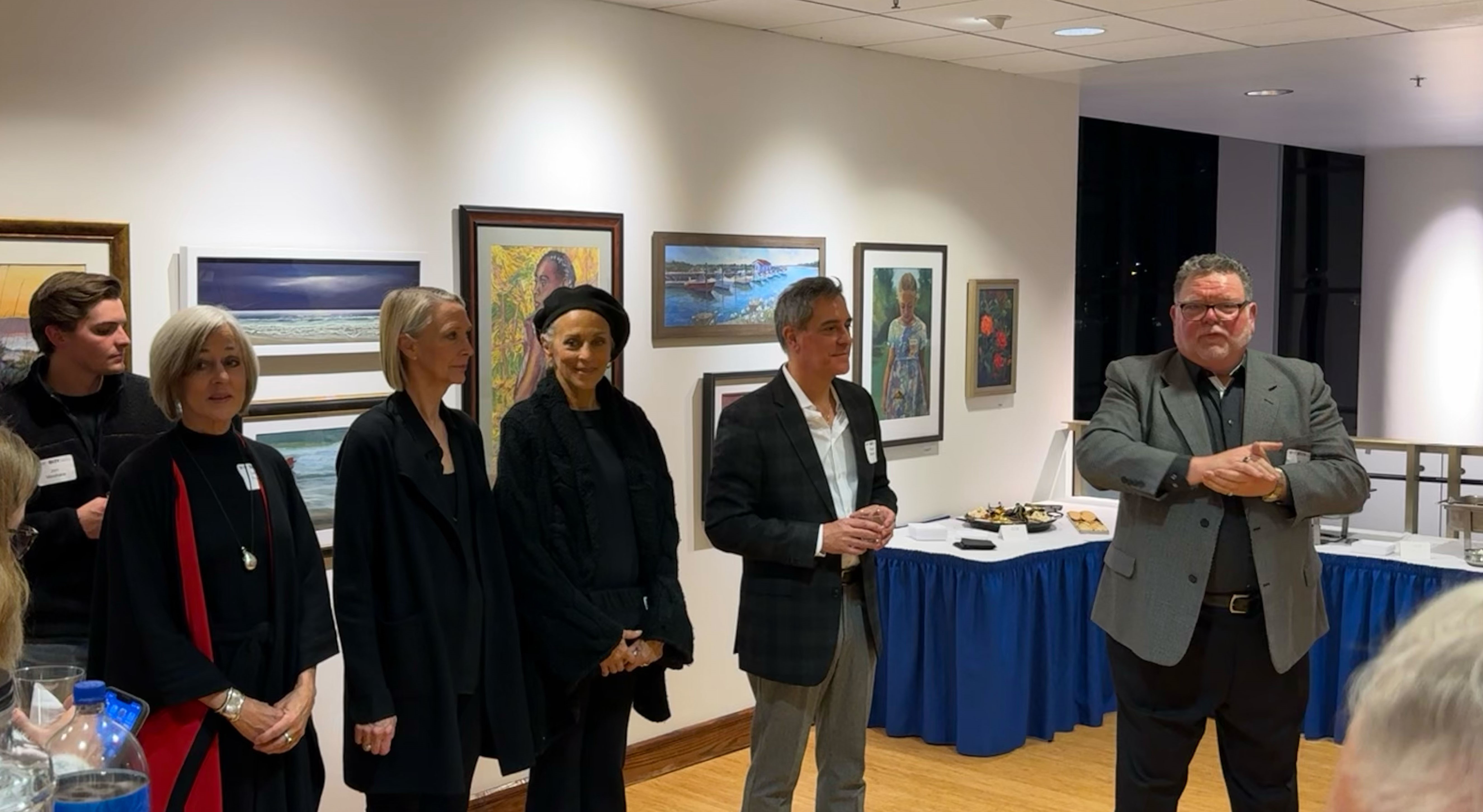 Community members and guest speakers gather in an art gallery for a cultural event