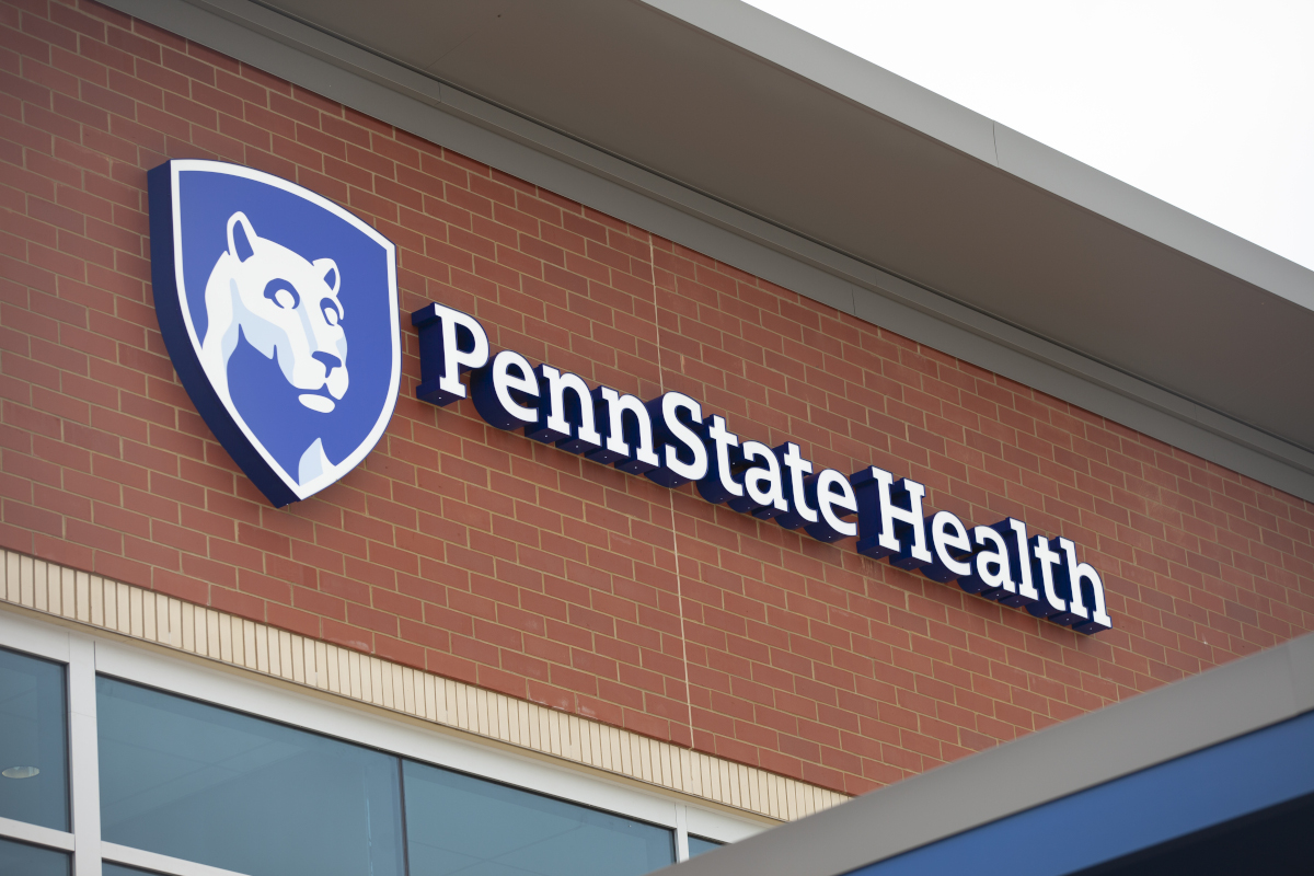 A Penn State Health sign mounted on a red brick building.