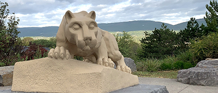 Nittany lion shrine with mountains and trees in background