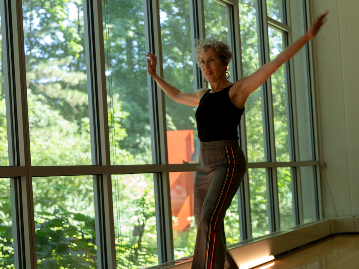 Michele Dunleavy dances in a dance studio in front of windows