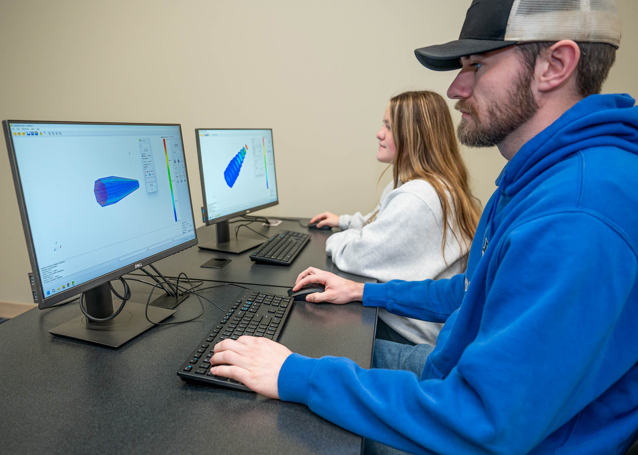 Two people work at computers together