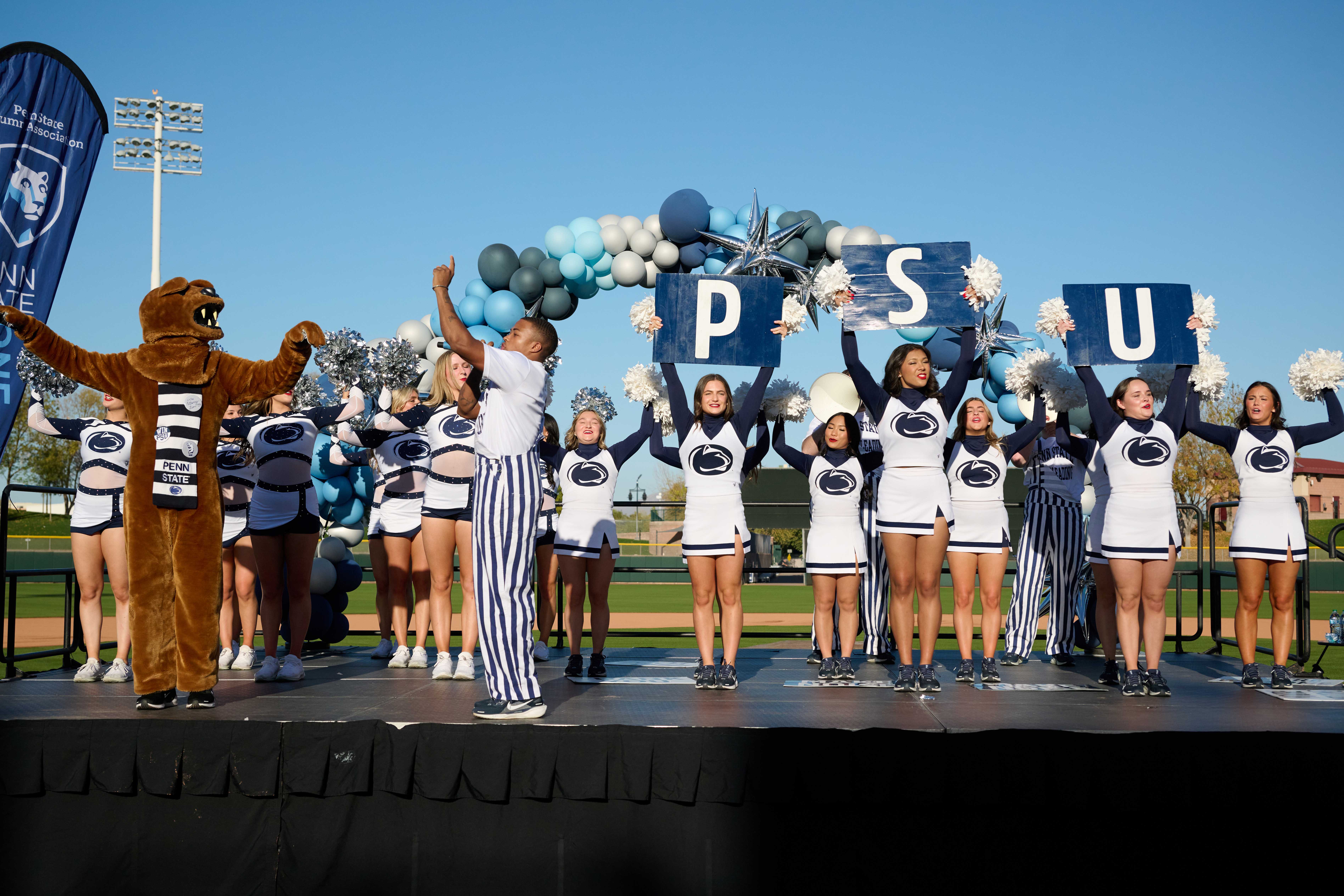 Penn State Cheerleaders and Nittany Lions performing on a stage on a baseball field