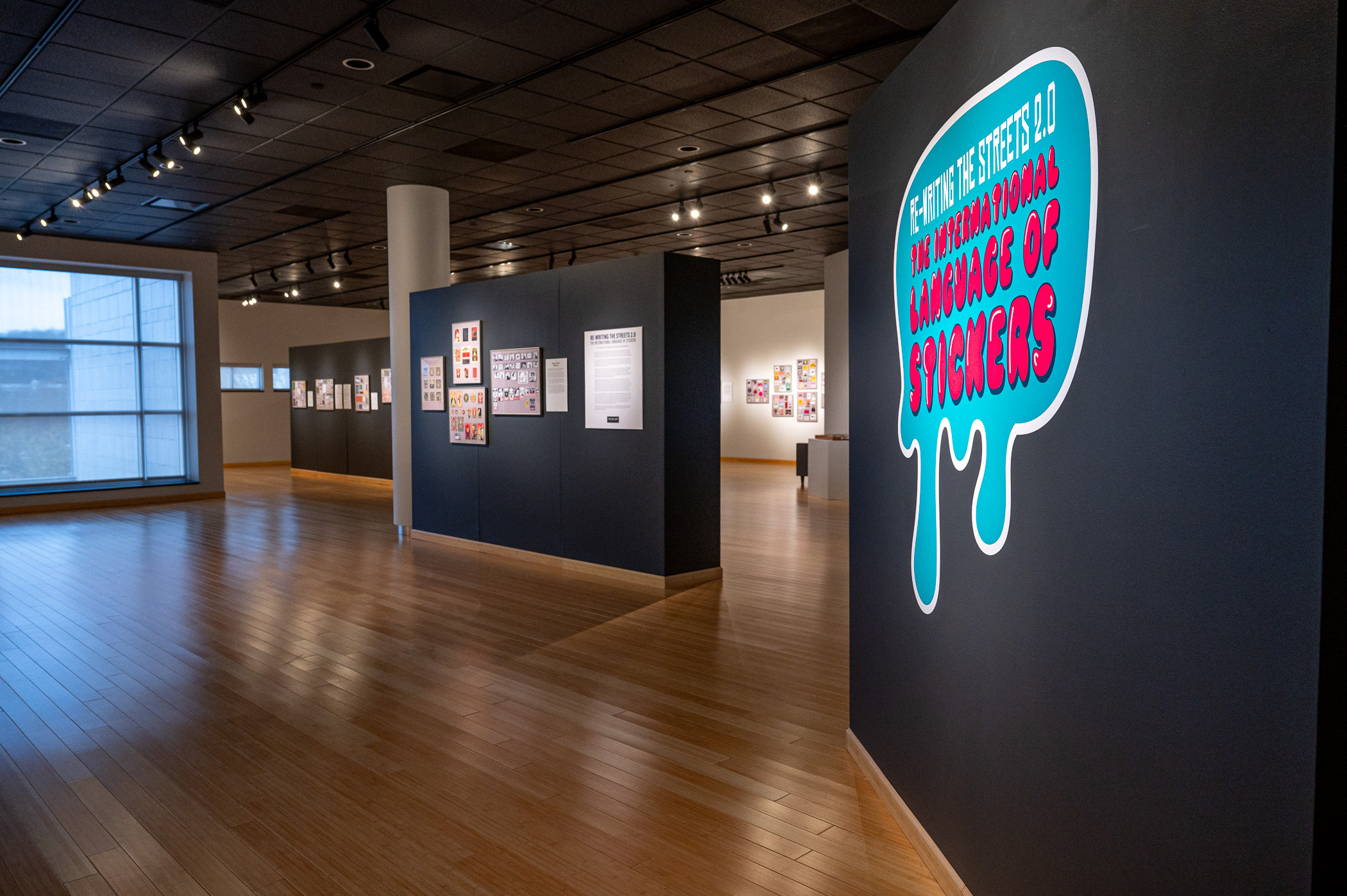 An art gallery features large colorful street stickers on the walls