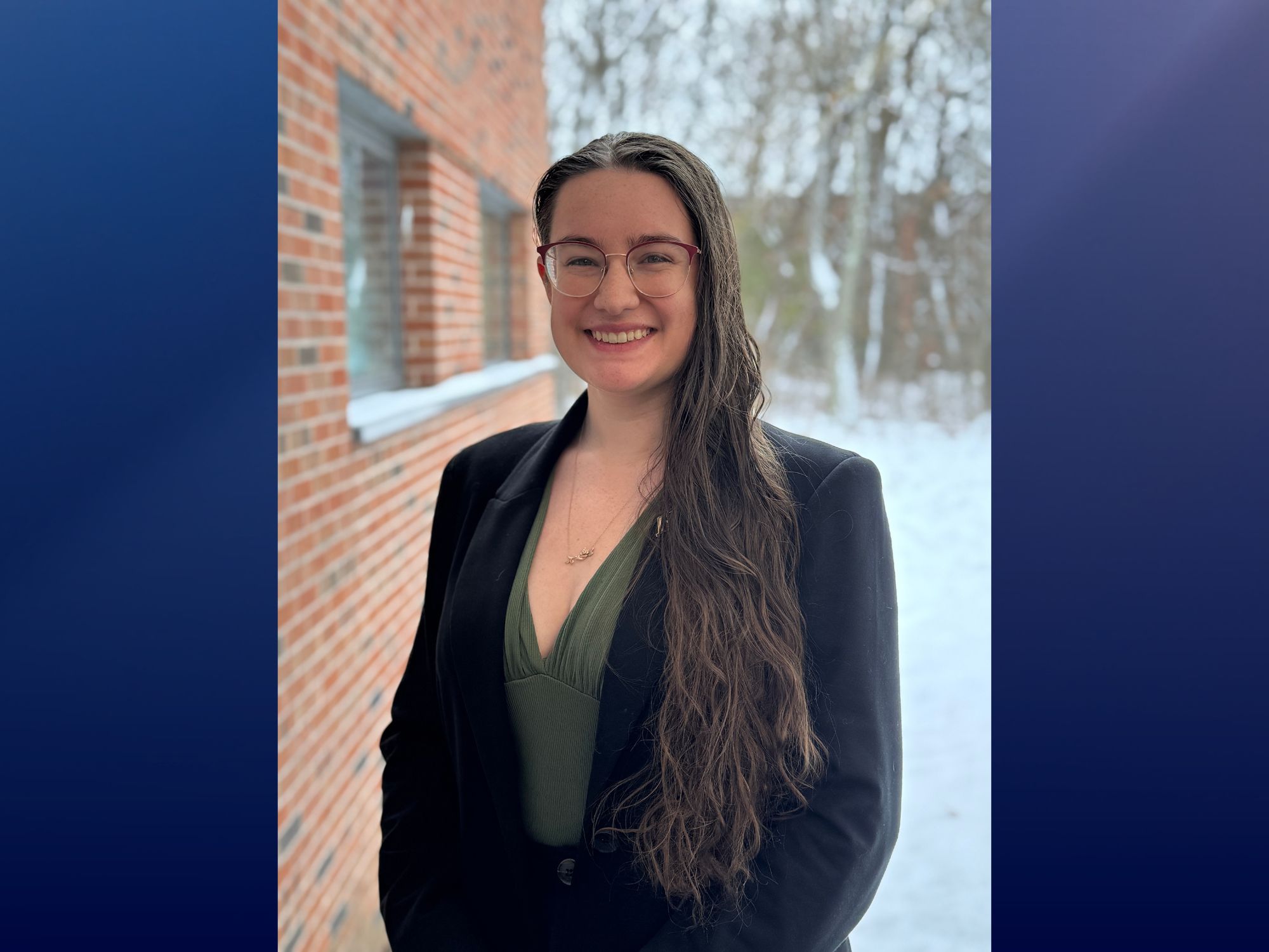 A portrait of Saraiha Rossi standing outside with a snow-covered background