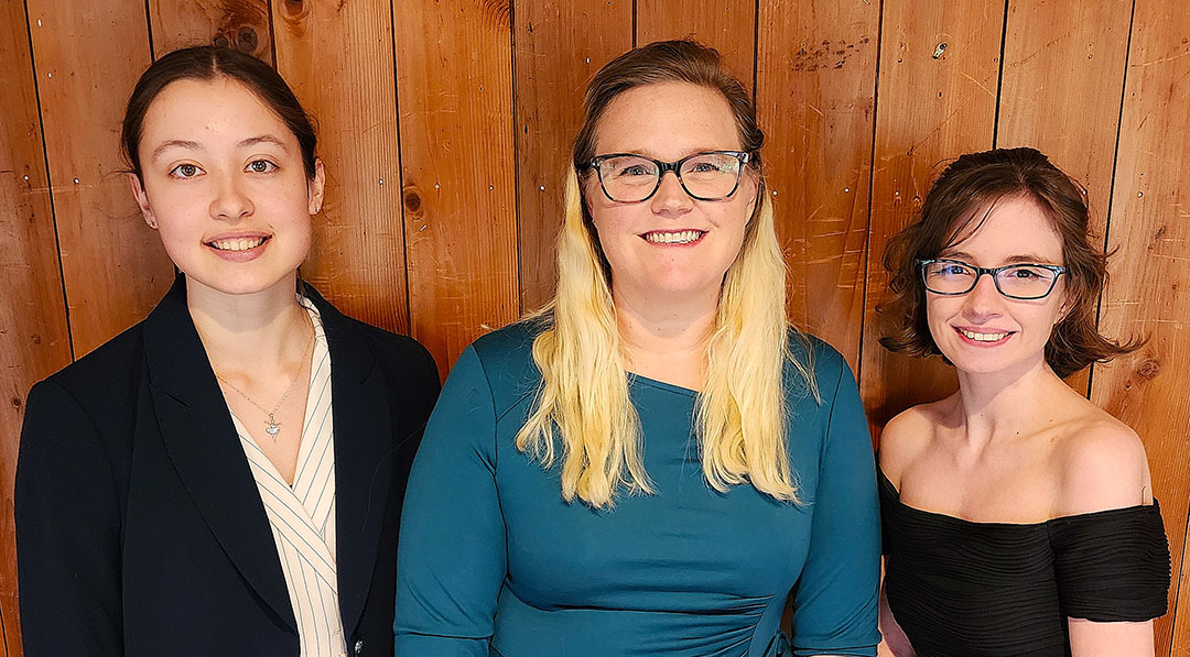 Three women standing next to each other.