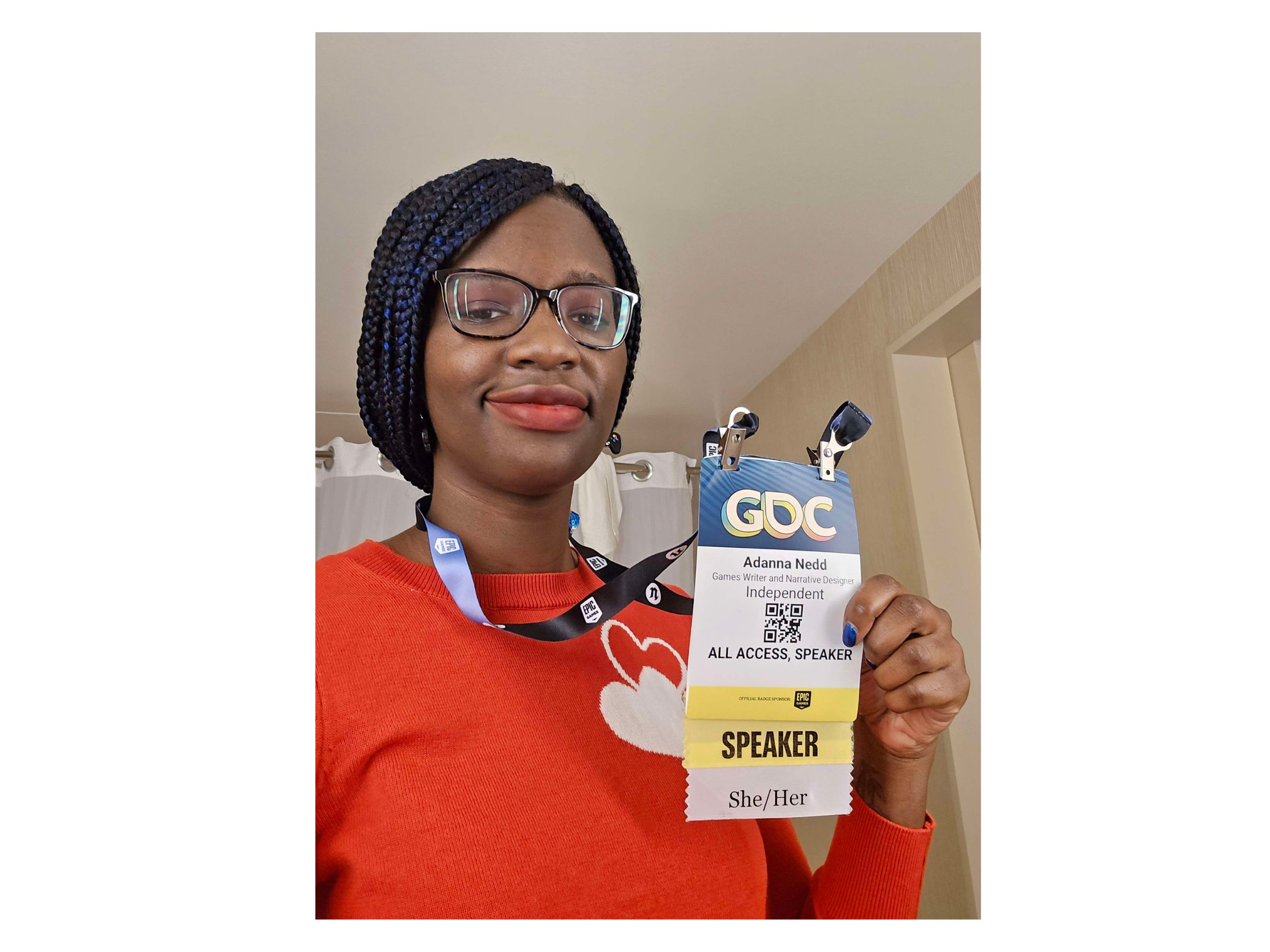 person with glasses shows off conference id tag