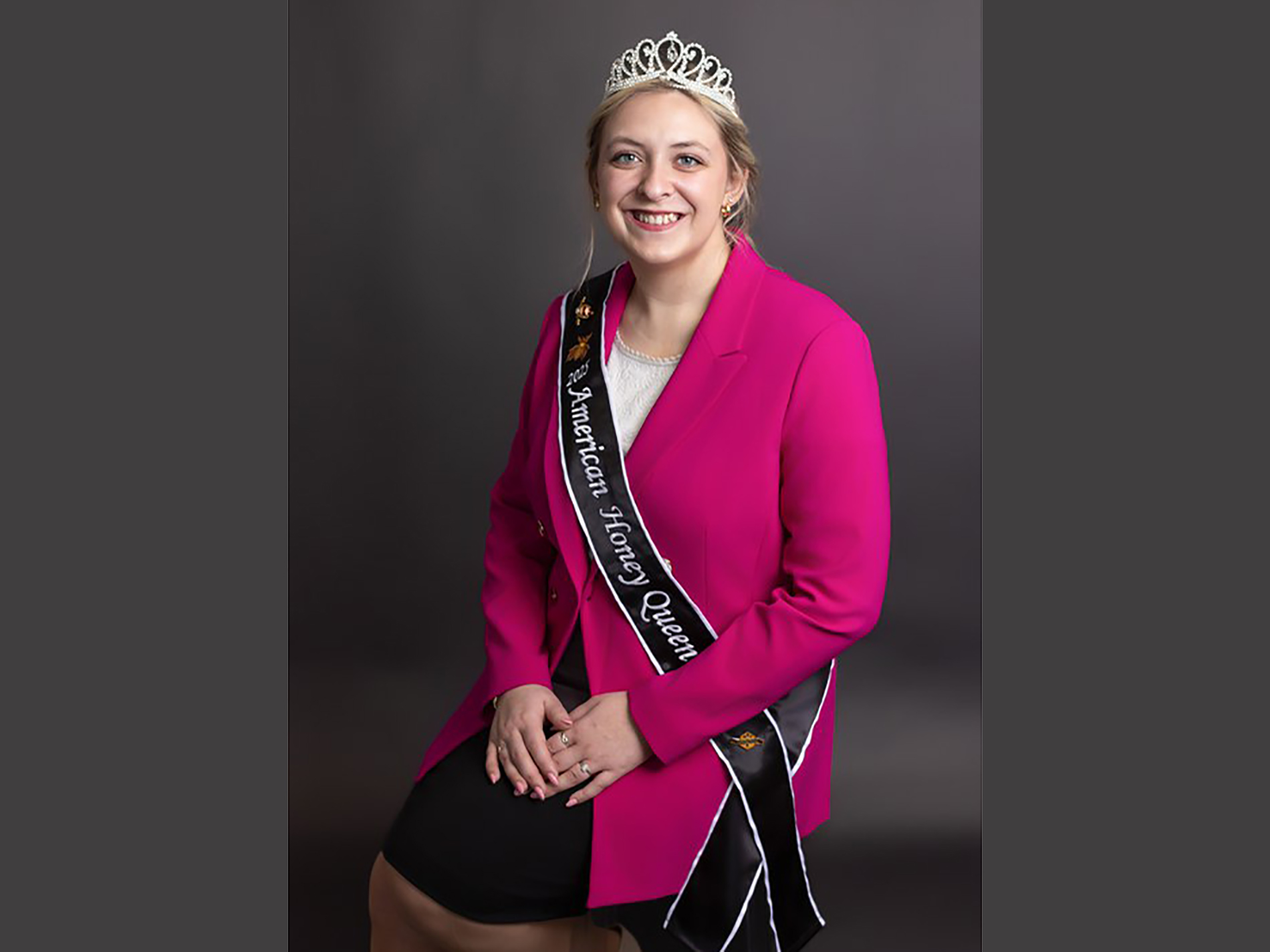 Cheyenne Brown, wearing a pink blazer, a tiara and a sash that says 2025 American Honey Queen