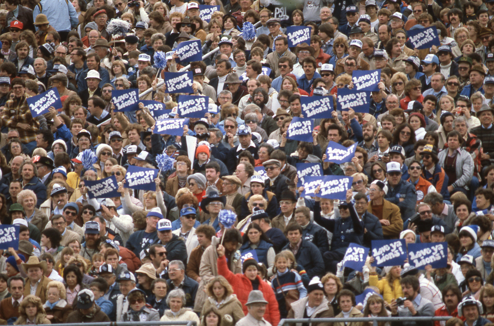 A crowd of Penn State football fans holding signs that read "Love Ya Lions"