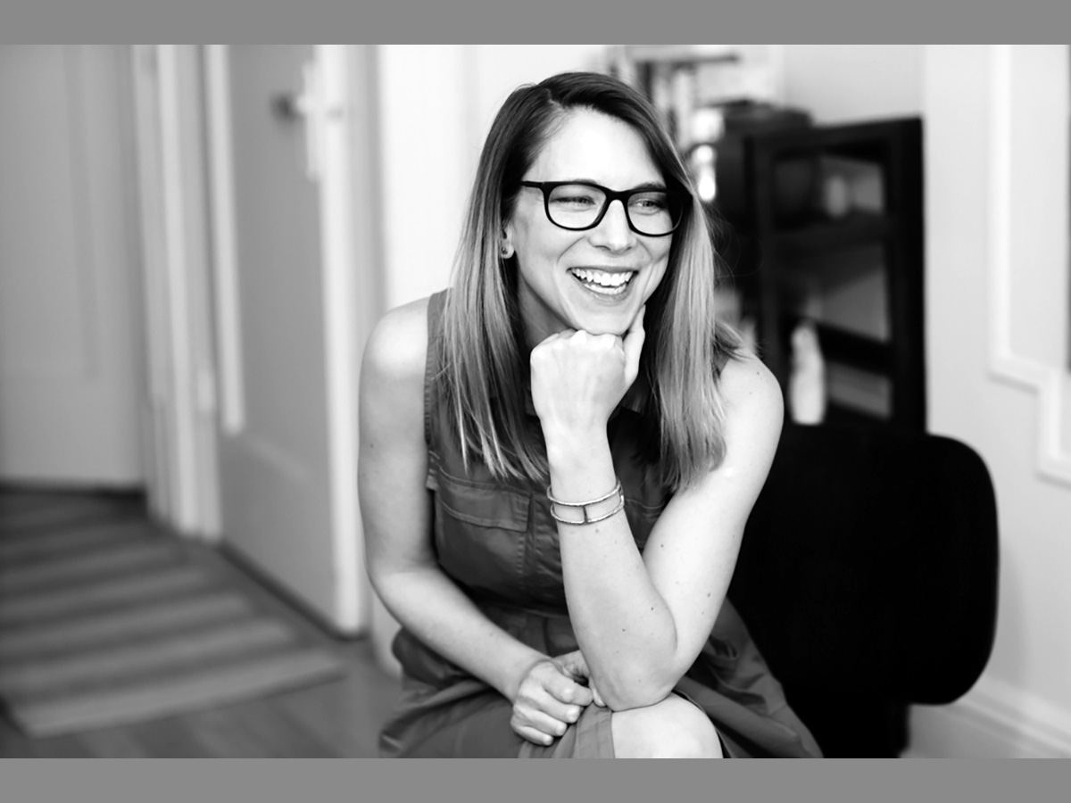 Black and white photo of essayist Kelly McMasters sitting in a chair