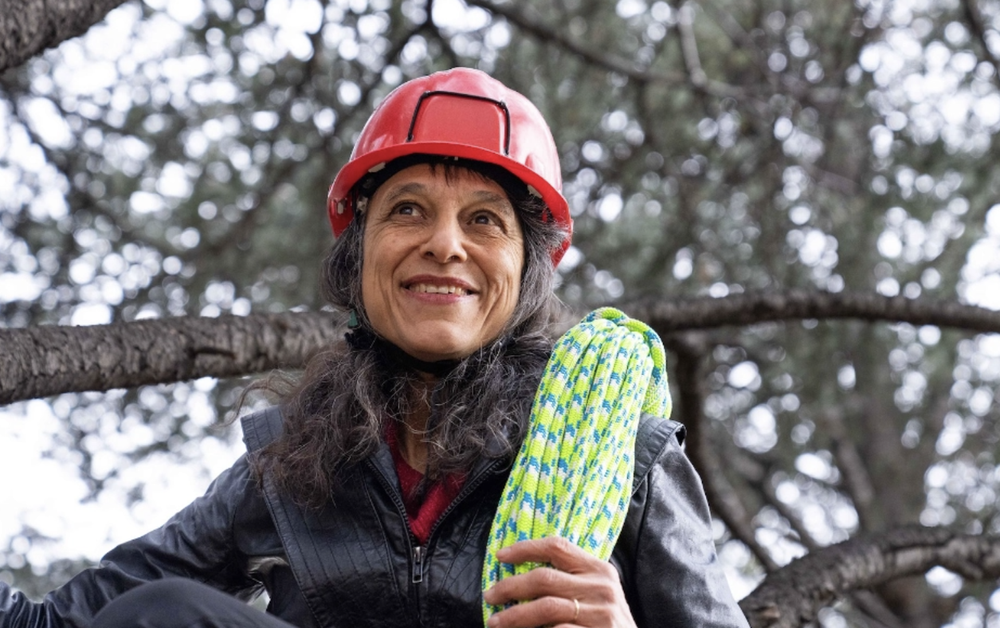 Ecologist Nalini Nadkarni wears a helmet and holds a rope for climbing trees and exploring tree ecology