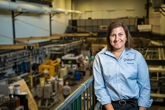 A graduate student stands on a balcony in Penn State Behrend's plastics engineering technology lab.