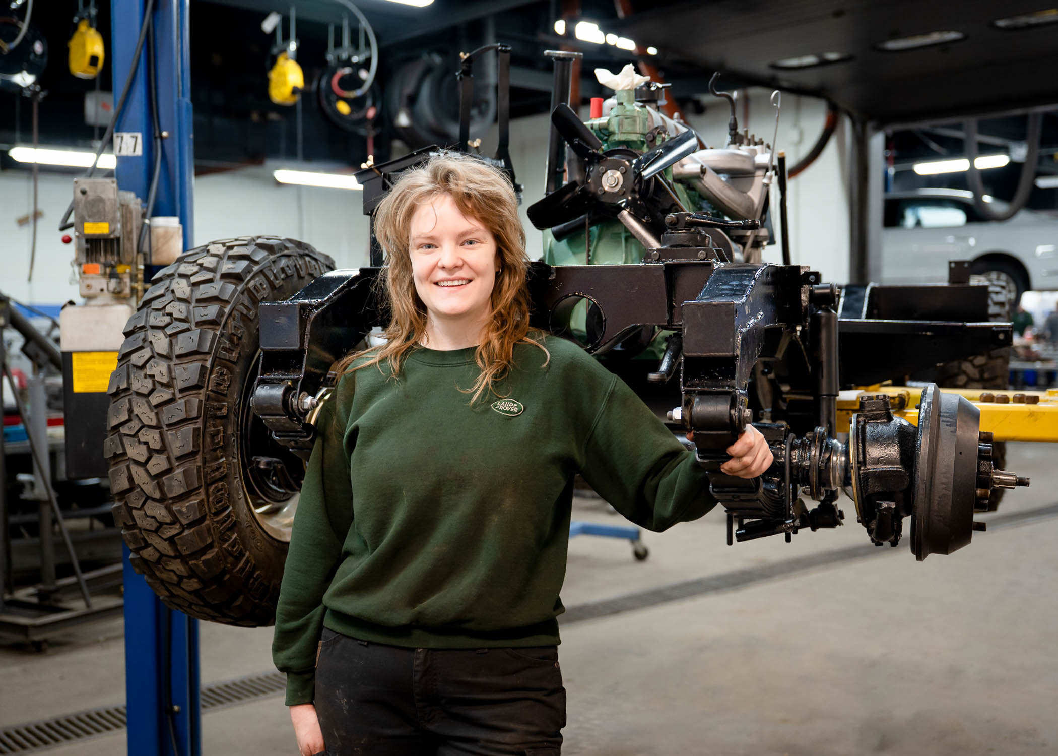 Sarah E. Crabtree stands in front of a bunch of car parts