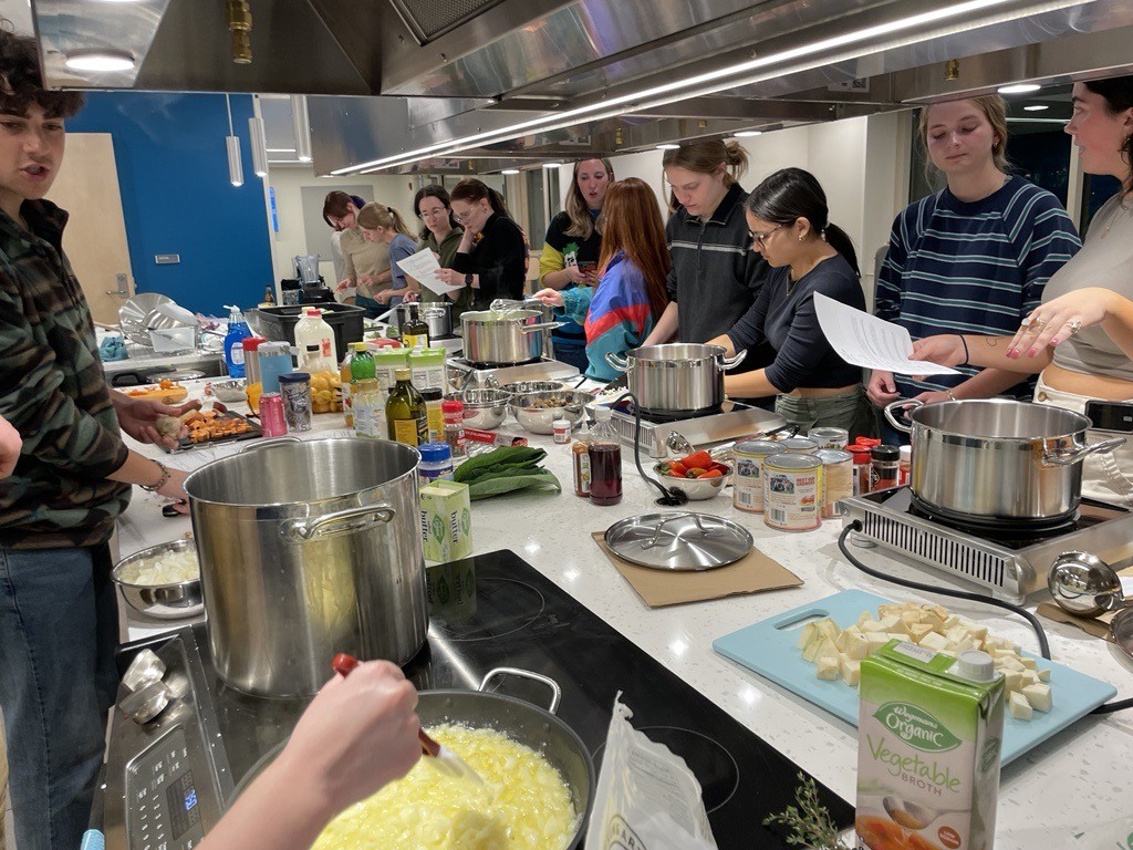 Students gather at the Stone Hall cooking demonstration area to make soup.