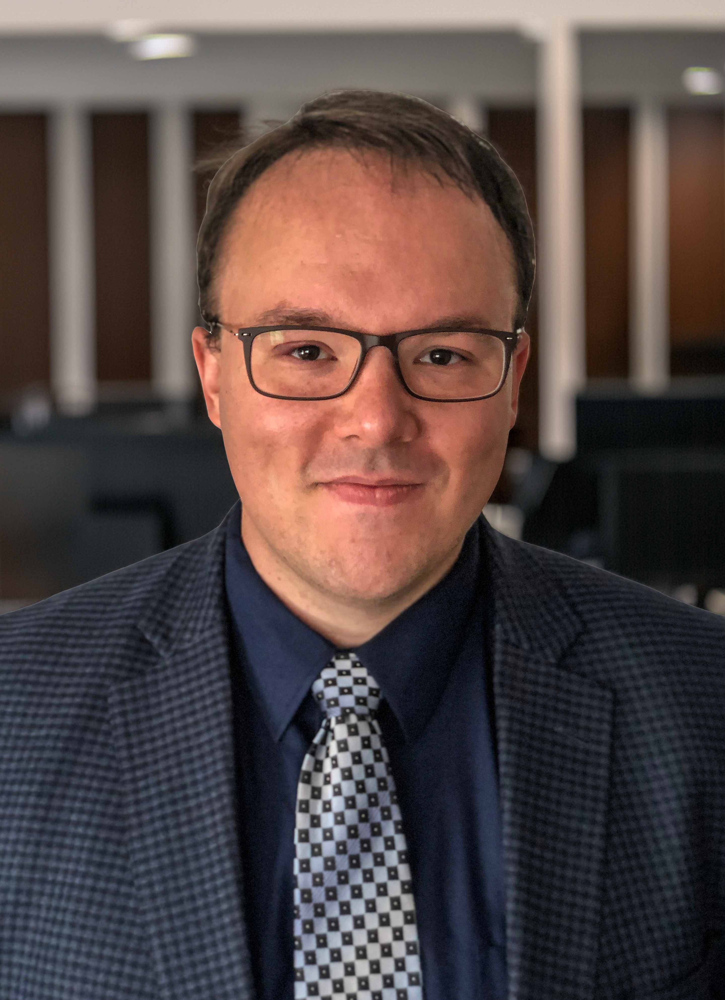 A person wearing glasses and a suit. 