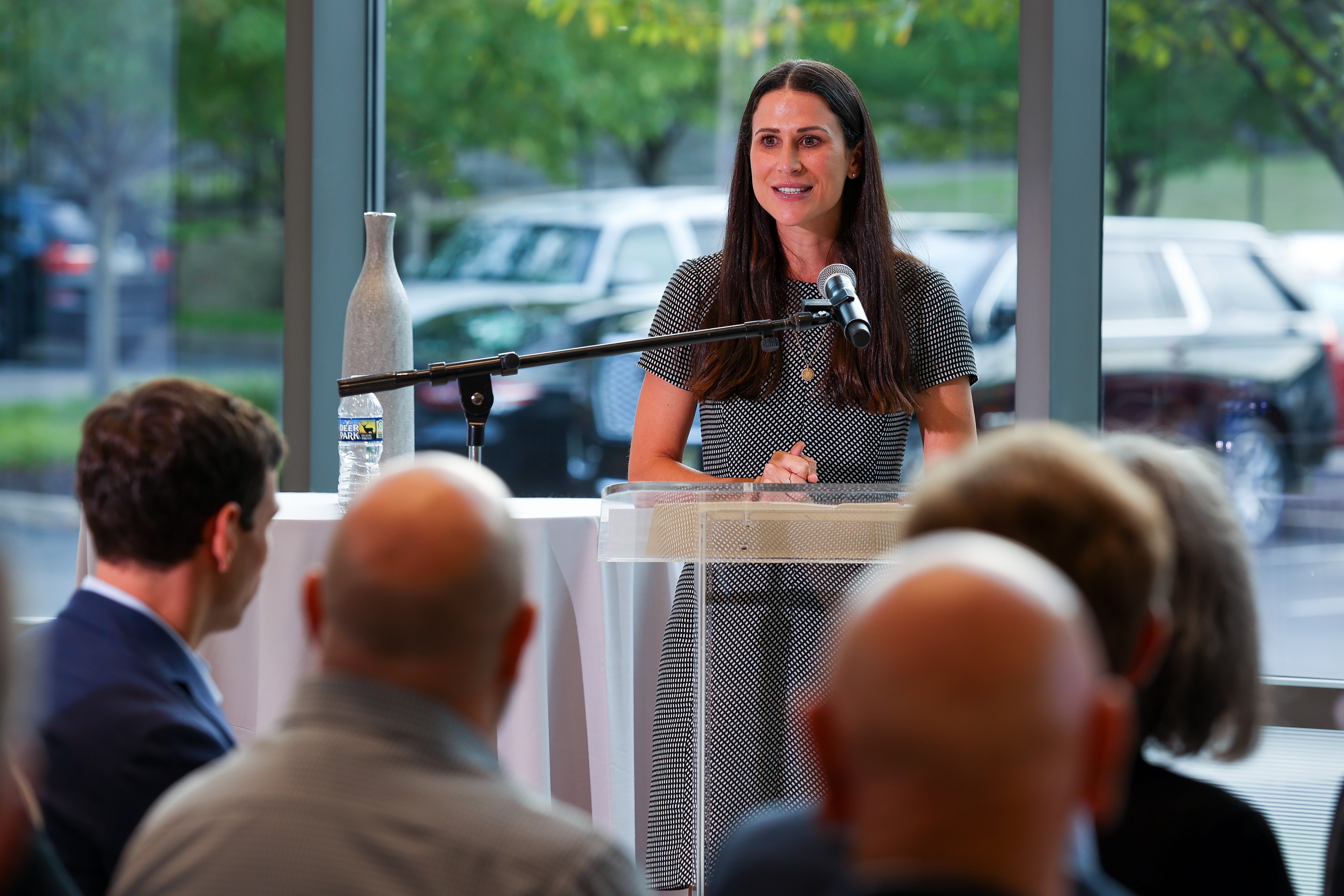 MBA alumna speaks at a podium in front of a group of people
