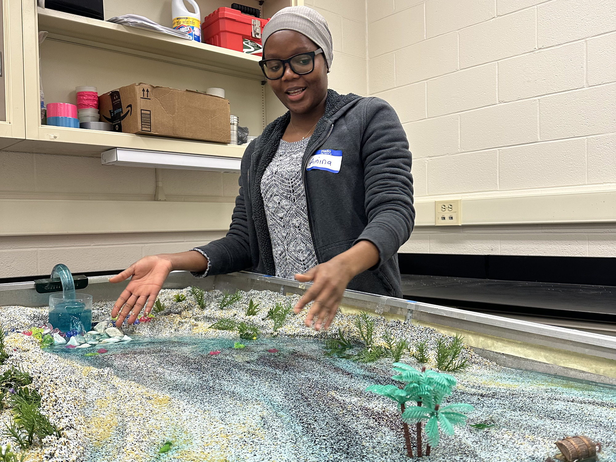 Geosciences graduate student Amina Abdulsalam shows how streams impact the landscape.