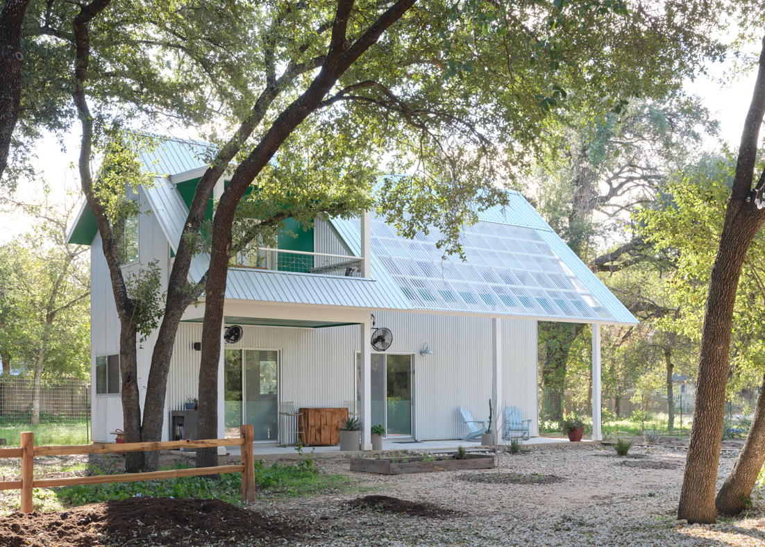 A white house with solar panels on the roof.